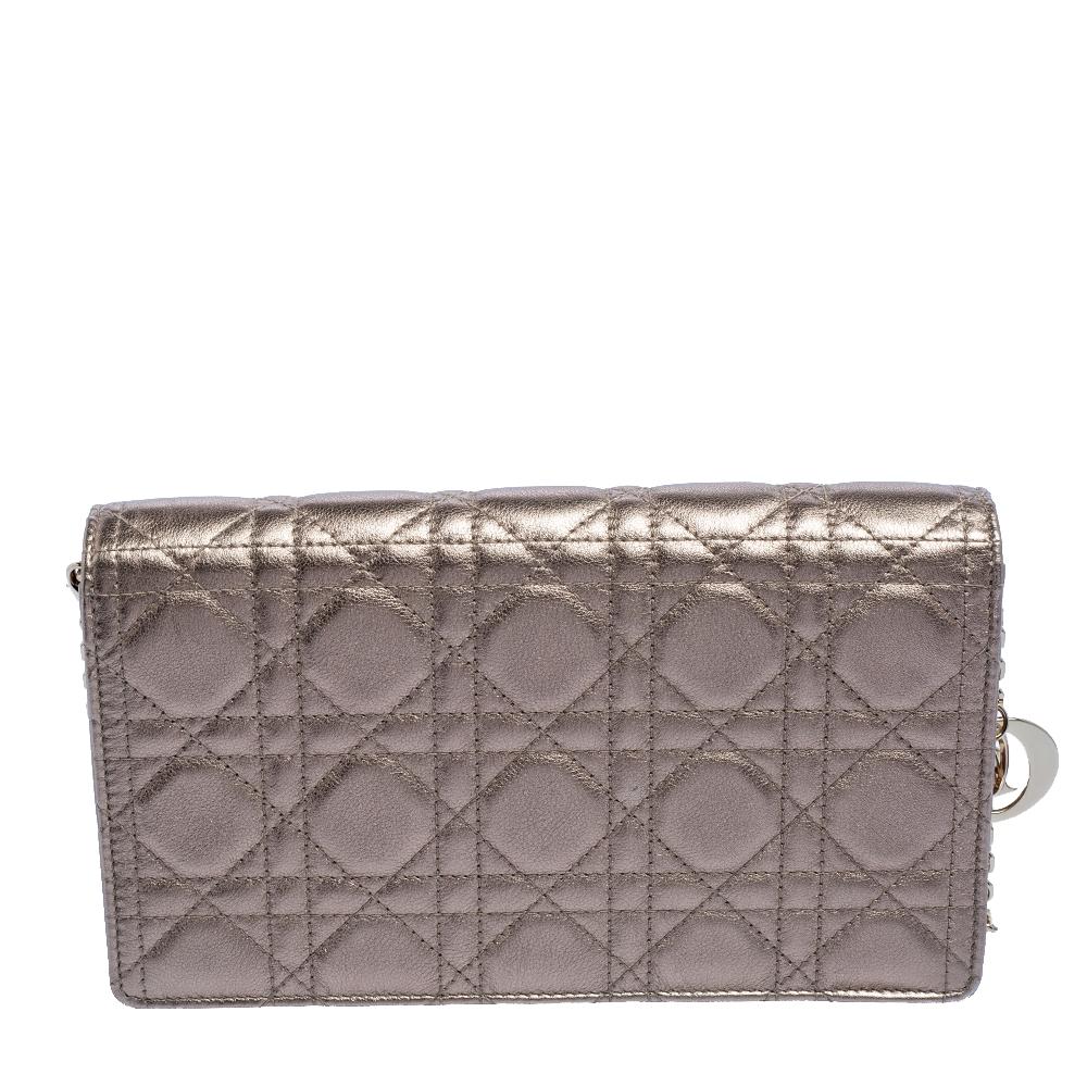 This Lady Dior pouch is a coveted bag that every fashionista craves to possess. This creation has been crafted from leather and it carries the signature Cannage quilt. It is equipped with a suede interior featuring a slip pocket and an open
