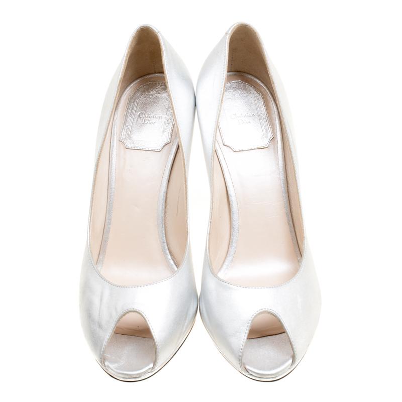 With a pair as gorgeous as these Dior pumps, you are sure to make an impression! The metallic silver pumps are crafted from leather and feature a peep-toe silhouette. They flaunt a brand logo plaque detailing on the heel counters and come equipped