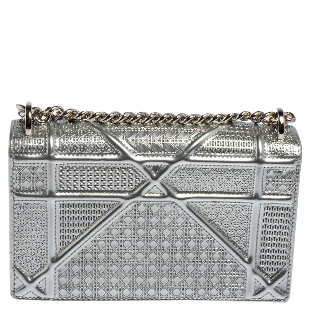 This Diorama bag is simply breathtaking! From its structured shape to its artistic craftsmanship, the bag sweeps us off our feet. It has been crafted from metallic silver leather and covered in the brand's signature Cannage pattern. A magnetic