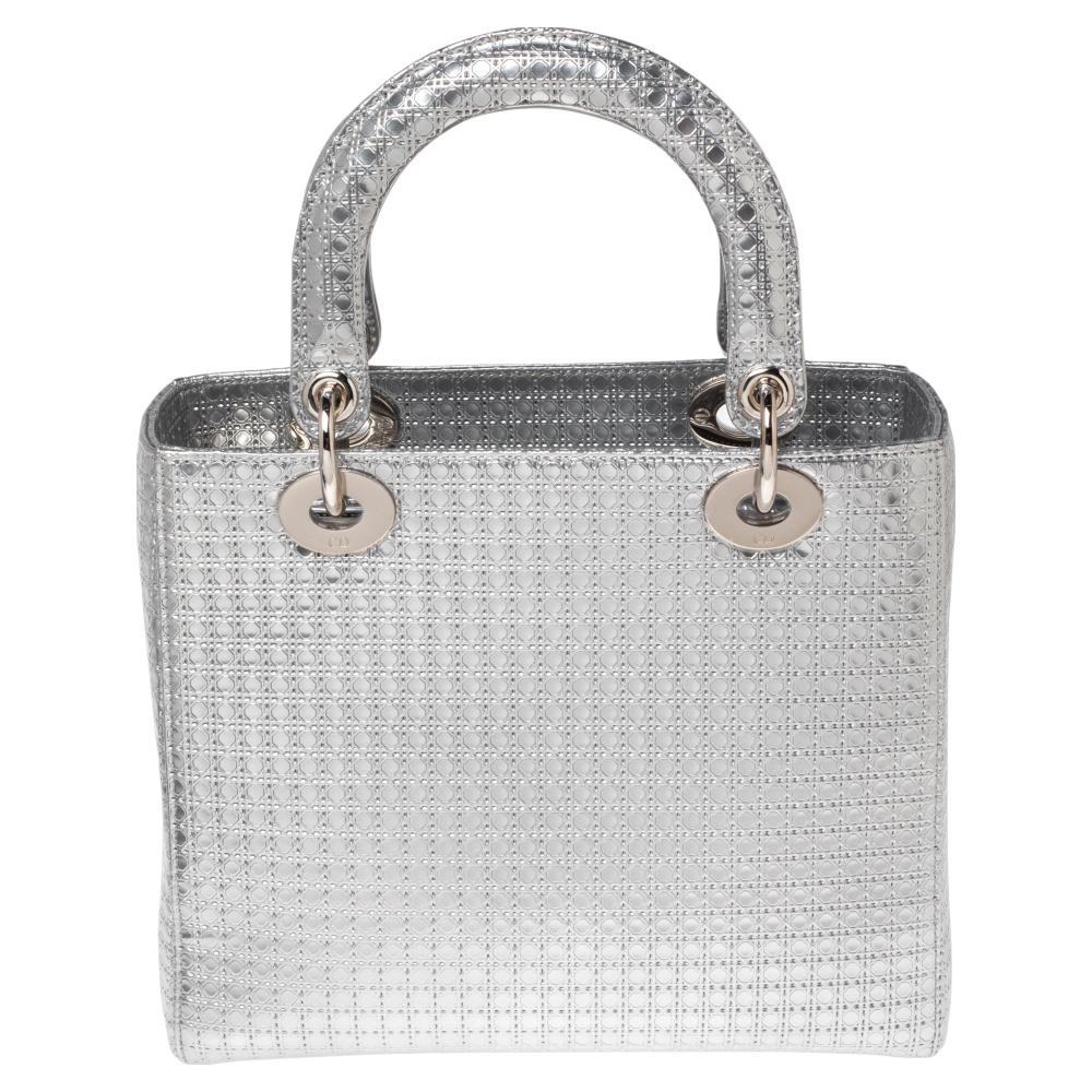 A timeless status and great design mark the Lady Dior tote. It is an iconic bag that people continue to invest in to this day. We have here this beauty crafted from metallic silver Micro Cannage patent leather. The bag has a spacious lined interior