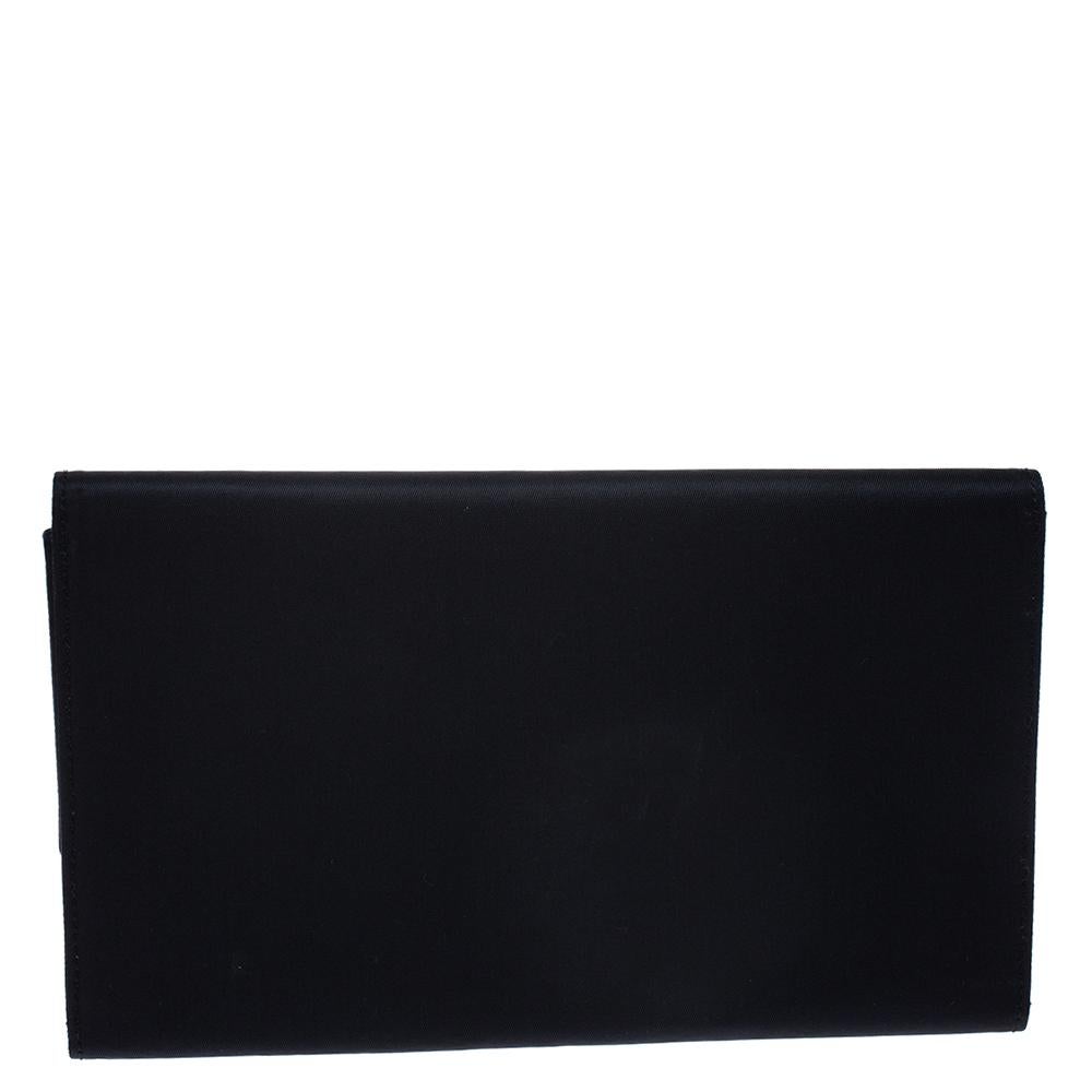 Sleek, smart and sophisticated, this Malice clutch comes from the iconic house of Dior. Crafted meticulously from quality nylon and patent leather, it carries a lovely shade o midnight blue. It has a half-moon shaped logo detail in the front and