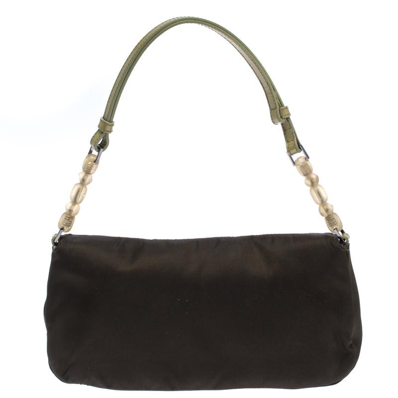 Every modern-day wardrobe needs a Dior handbag like this. A practical and elegant everyday bag in a lovely green hue, this one is made from satin. It is held by a single handle, features silver-tone hardware and comes with a well-sized fabric
