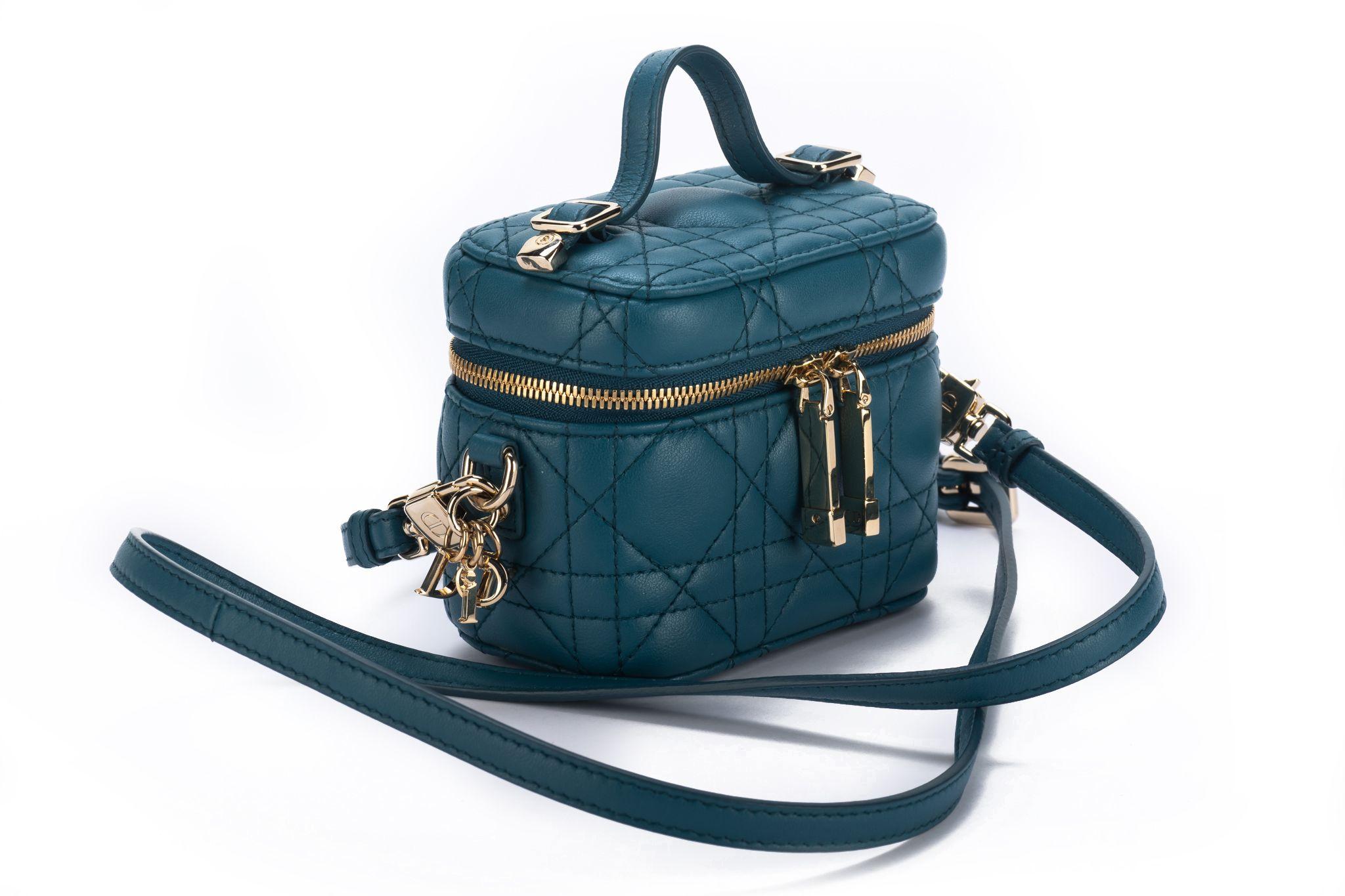 Dior mini travel case in turquoise can age quilted leather and gold tone hardware. Handle drop 1.5, shoulder drop 21. Comes with ID card and original dust cover.