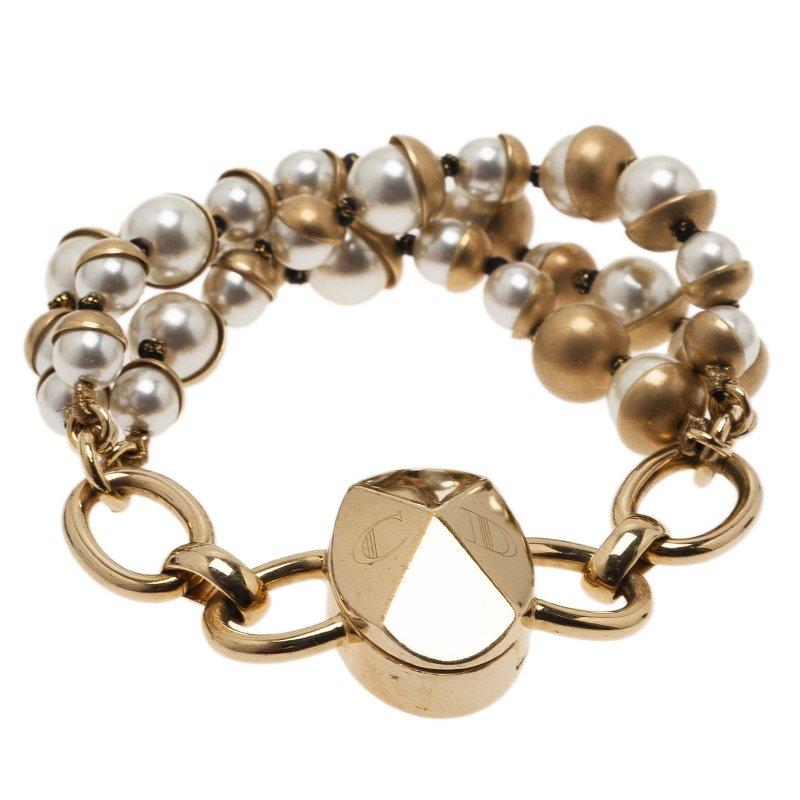 Adorn your wrist with this fascinating Dior Mise and Dior bracelet crafted in white faux pearls woven in triple strings and set in gold-tone metal. It comes with a brand initials engraved on the metal. Sure to go well with any party wear