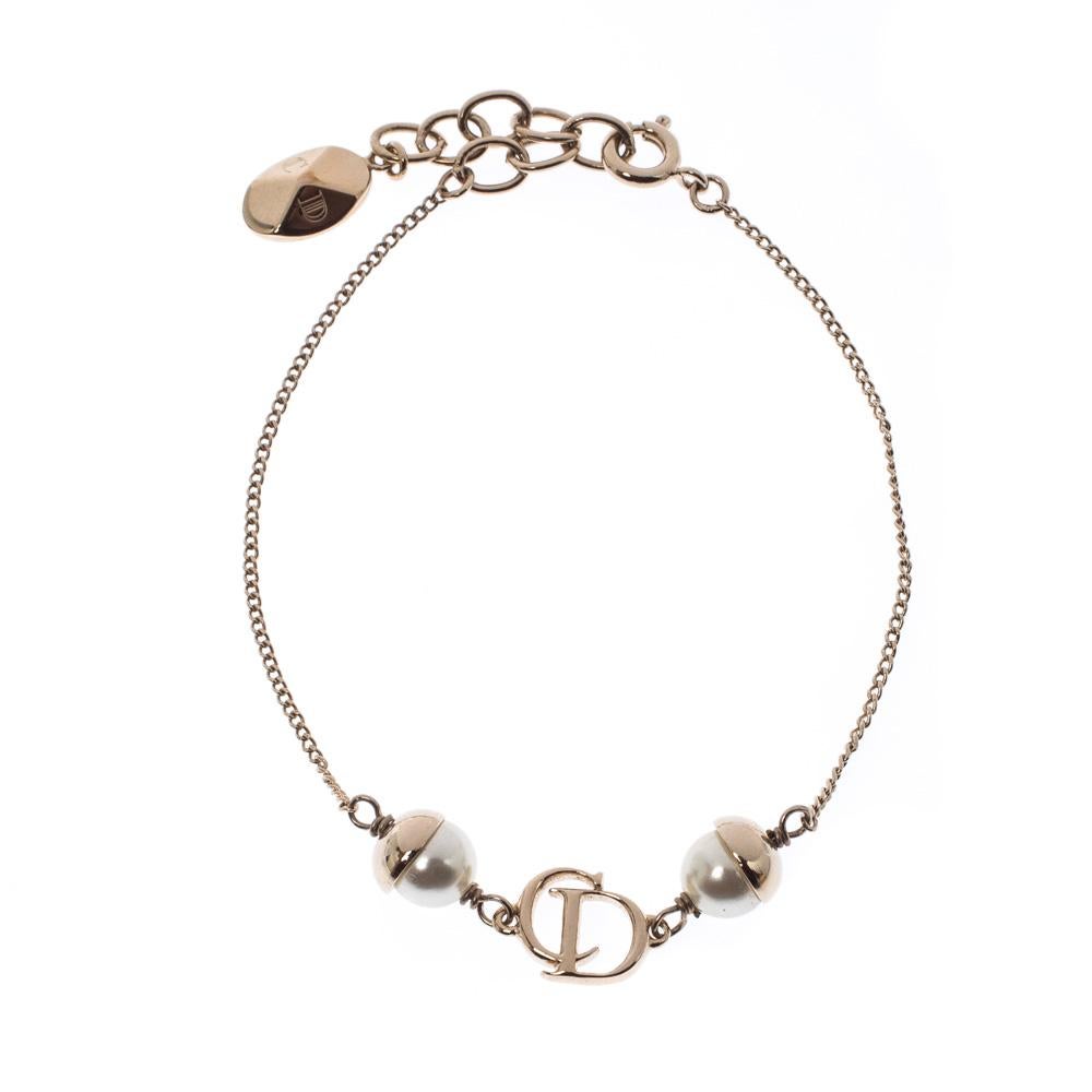 This gorgeous gold-tone Mise En Dior bracelet is no short of plain-sailing charm. Part of a collection that refurbished the glory of pearl jewelry, this bracelet has a beautiful CD logo with spring ring closure. Day in or a day out, this bracelet