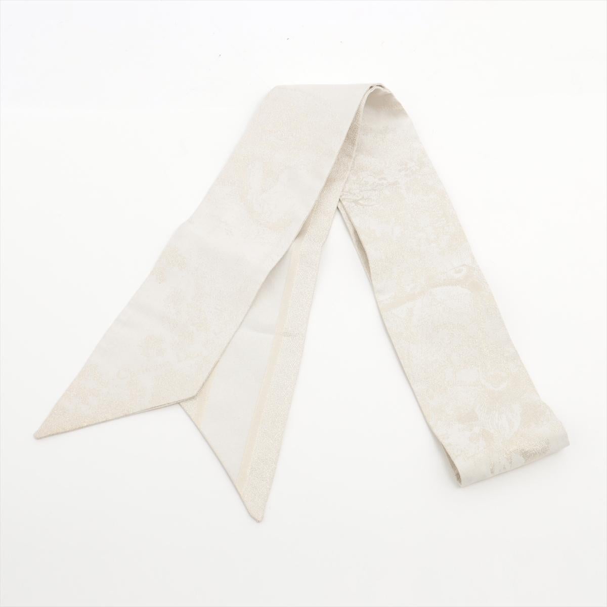 The Dior Mitzah Twilly Silk Scarf in Ivory is an exquisite accessory that epitomizes elegance and sophistication. Made from luxurious silk, the twilly scarf features a delicate ivory hue that exudes timeless charm and versatility. Adorned with