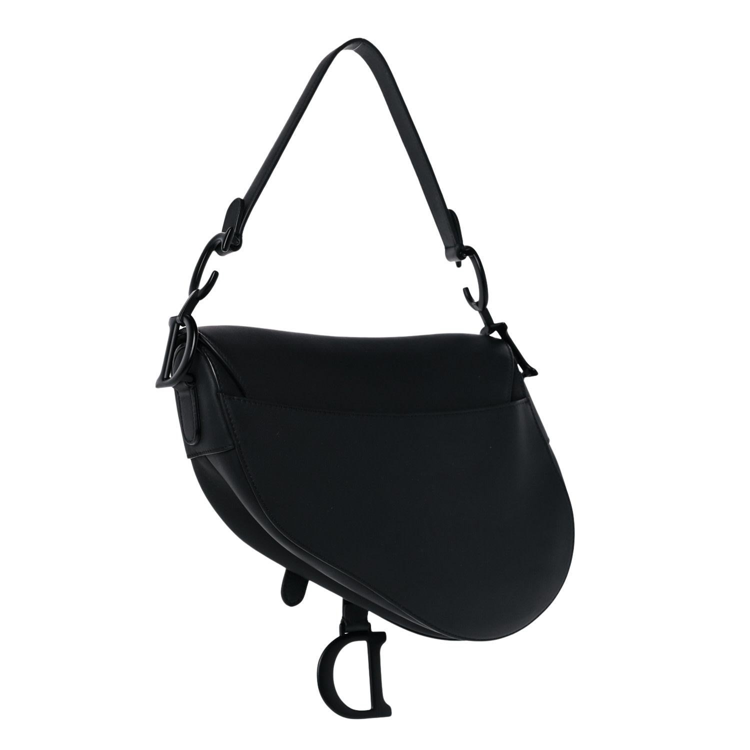 This bag features Dior's classic saddle bag shape and is made of black leather. The bag features a monochrome effect, matte black hardware, logo charms and front flap closure. The bag opens to a matching suede interior with a zip pocket.

Material: