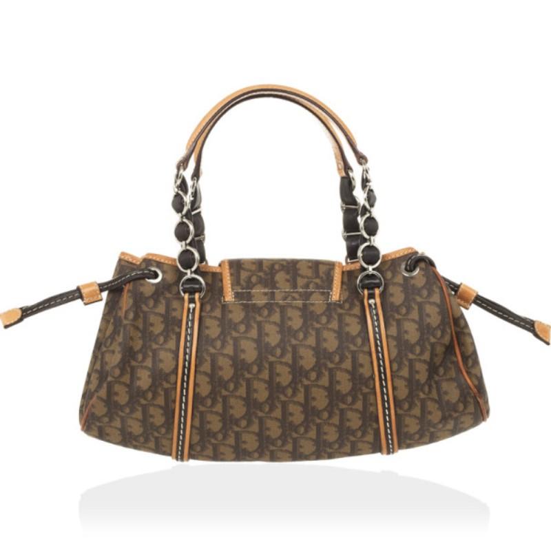 Carry this charming Trotter Romantique satchel by Dior everywhere. With an exterior made from Dior’s monogram canvas and leather trim, it is beautifully detailed with a bow, a Dior heart lock and embellished handles. The interior is lined with brown