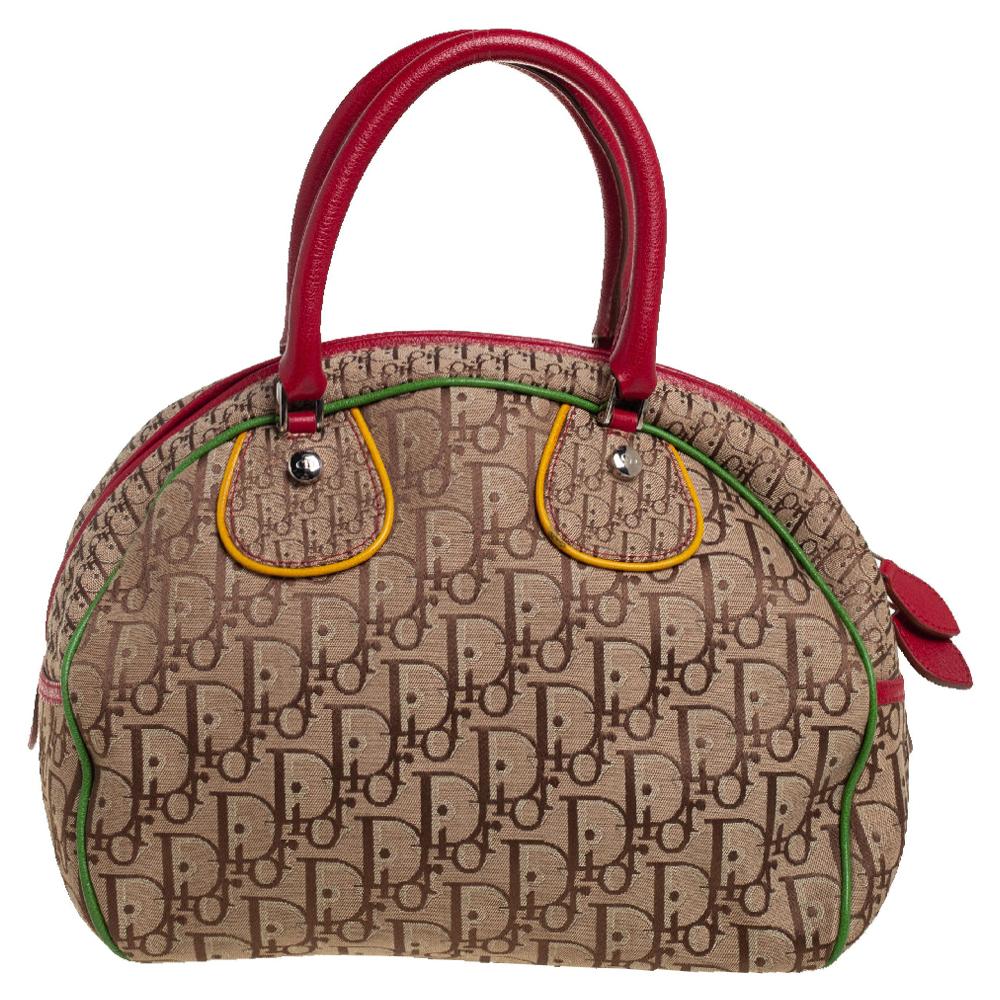 Part of the Rasta collection, this Dior bowler bag is cute with a pop of color. Its Diorissimo canvas exterior is designed with leather trims of the Rasta colors—red, yellow, and green. Featuring a zip closure, its nylon-lined interior includes a