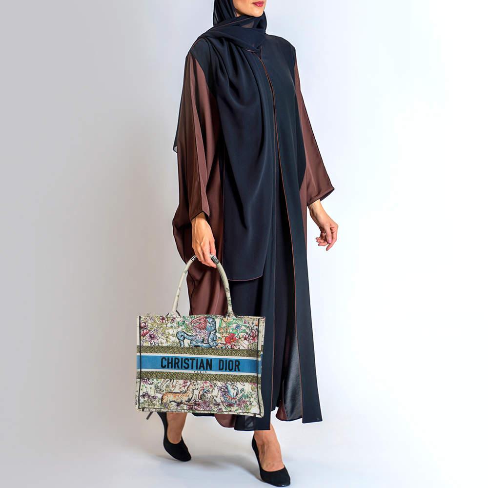 Designed by Maria Grazia Chiuri  the Dior Book Tote is a travel accessory for people with style. The bag here is crafted using canvas into a beautiful structure and is covered in embroidery. Two handles  the Christian Dior signature  and a spacious