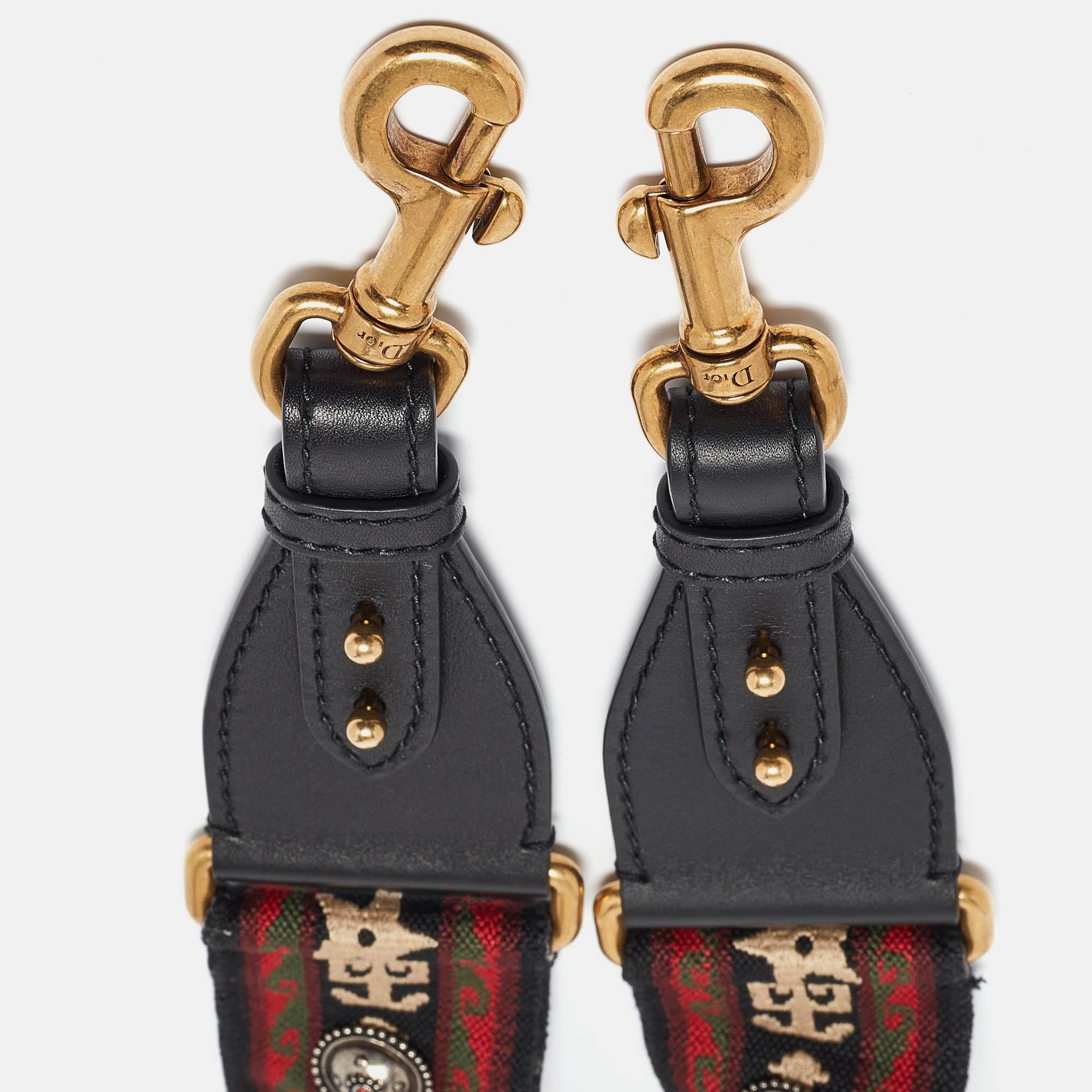 Dior brings you this super-chic shoulder strap that you can flaunt with your collection of handbags. The strap is made from canvas added with stud details and leather trims. It is complete with two metal clasps for you to attach the strap to your
