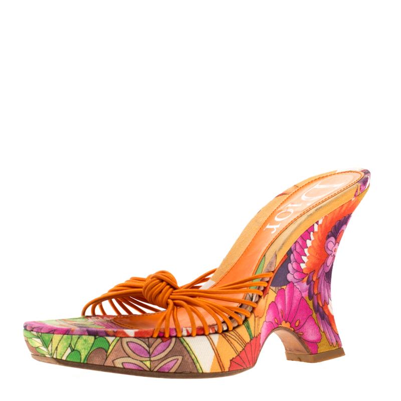 Dieses Paar von Dior sieht eher aus wie eine Blume als wie eine Sandale, so schön ist es! Die Pantoletten sind aus Leder gefertigt und mit geknoteten Riemen auf dem Oberteil und lebhaften Blumenprints auf den Keilen versehen.

