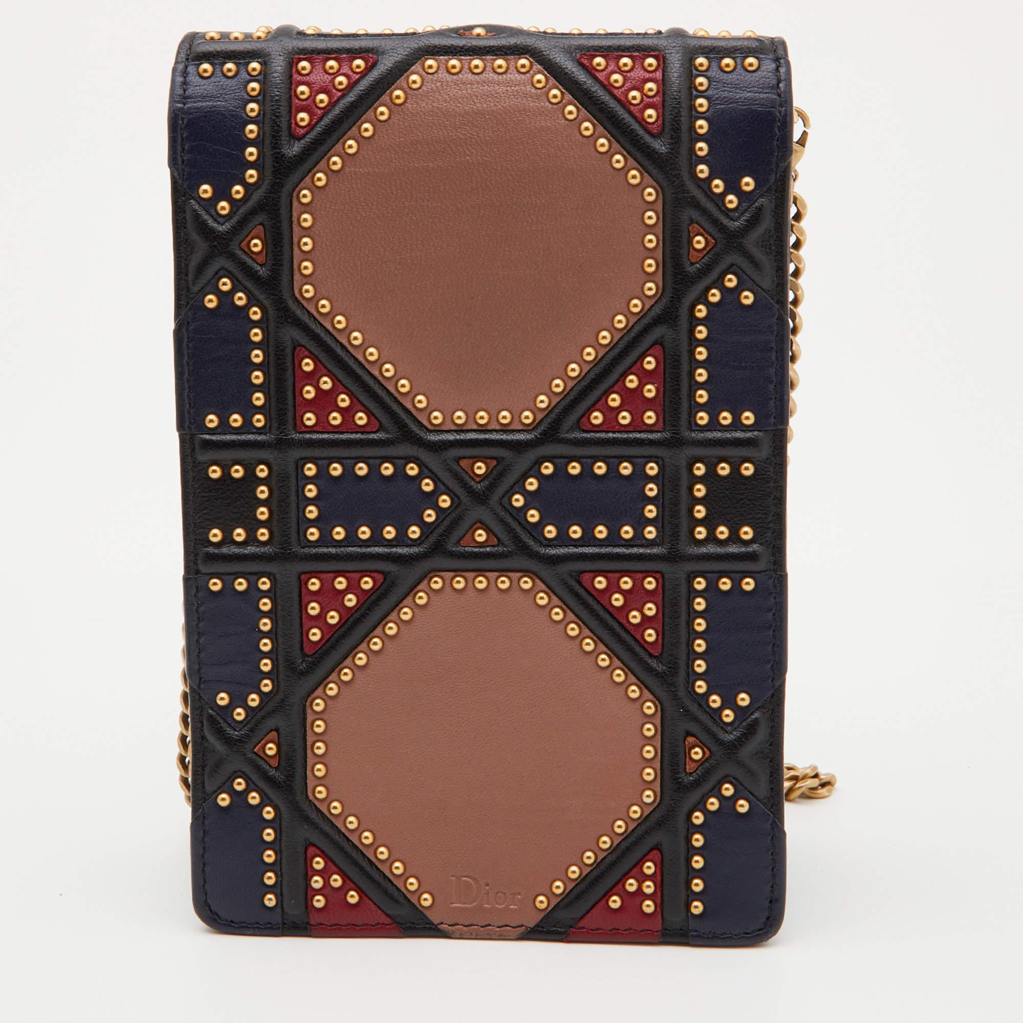 This Diorama clutch is adorable! It has been crafted from leather and detailed with studs in the brand's Cannage pattern. The signature crest sits on the flap securing two compartments while a shoulder chain is provided for you to carry