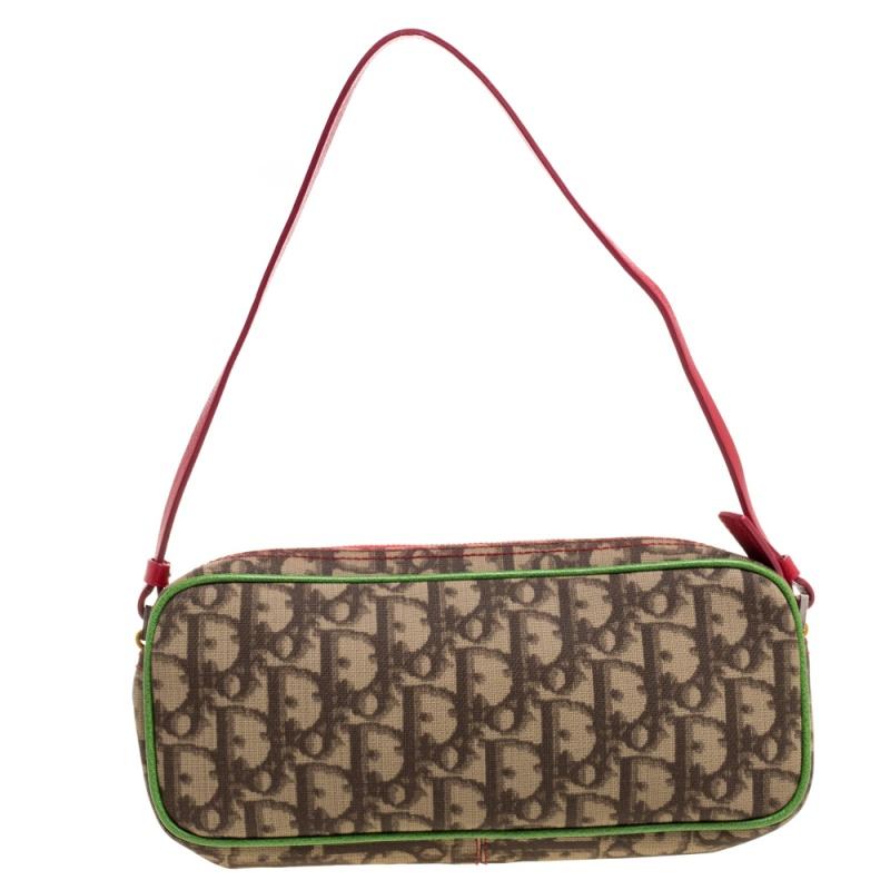 Part of the Rasta collection, this Dior pochette is cute with a pop of color. Its Obique canvas exterior is designed with the Rasta colors of red, yellow, and green. Featuring a zip closure, its fabric-lined interior includes a patch pocket for easy