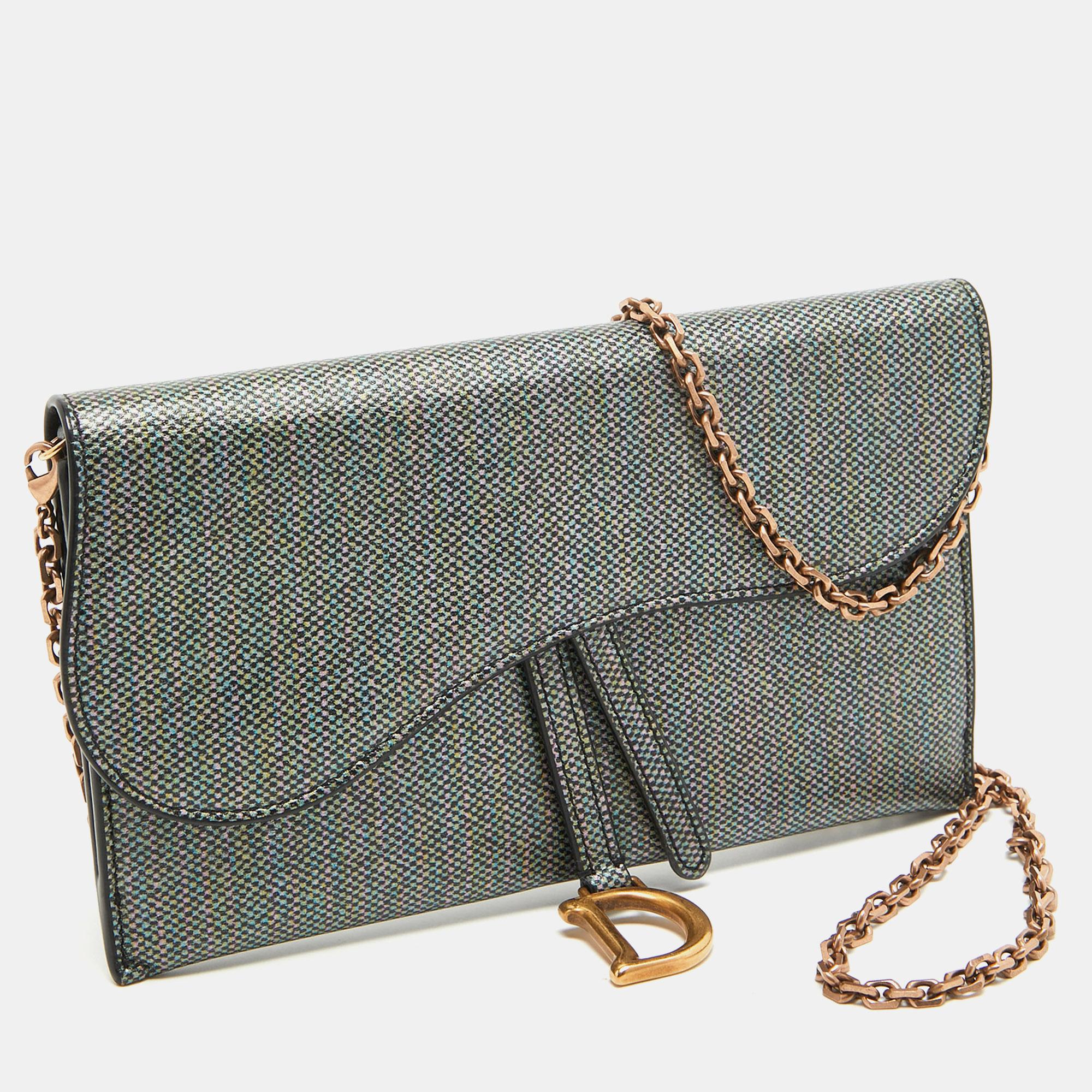 This Saddle wallet on chain from the House of Dior brings you endless functionality, style, and luxury! It is made from multicolor printed leather, with a rose gold-tone D charm perched on the front. It accommodates a leather-lined interior and a