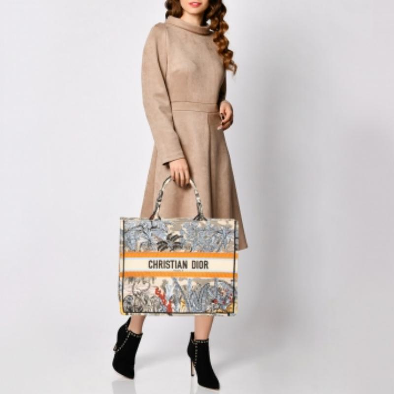 Designed by Maria Grazia Chiuri, the Dior Book Tote is a travel accessory for people with style. The bag here is crafted using canvas into a beautiful structure and is covered in signature prints all over. Two handles, the 'Christian Dior'