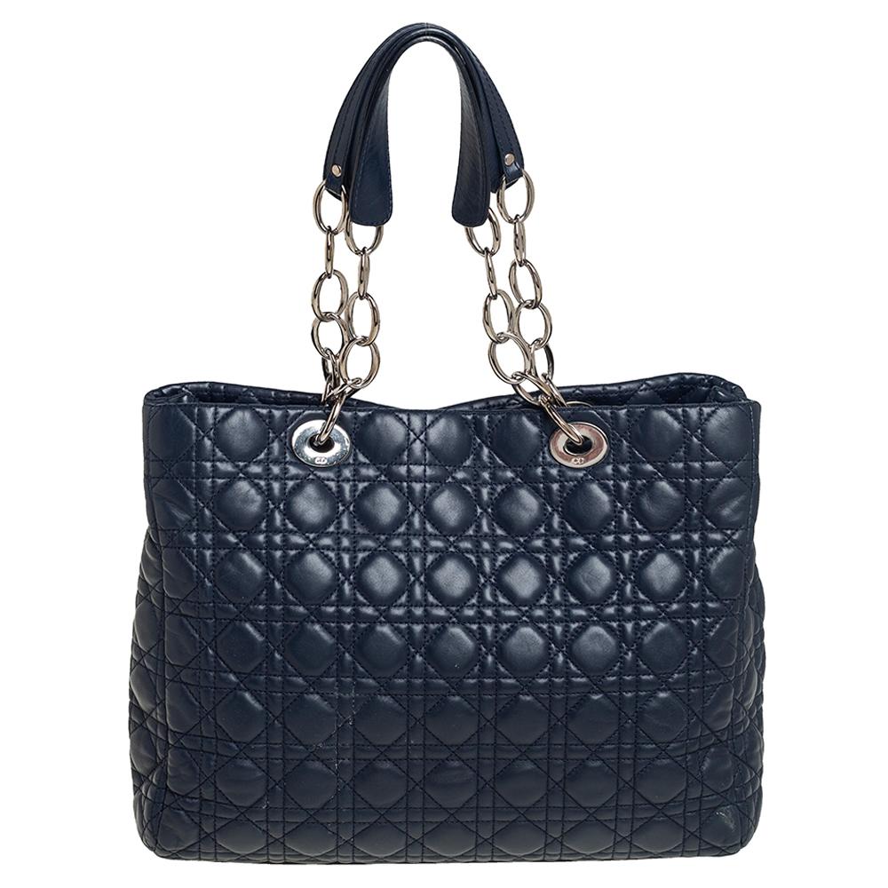 Impressive and high on style, this Lady Dior shopper tote from Dior comes made from navy blue leather and features the signature cannage quilted pattern on the exterior. It has dual top handles carrying attached 'DIOR' letter charms and a