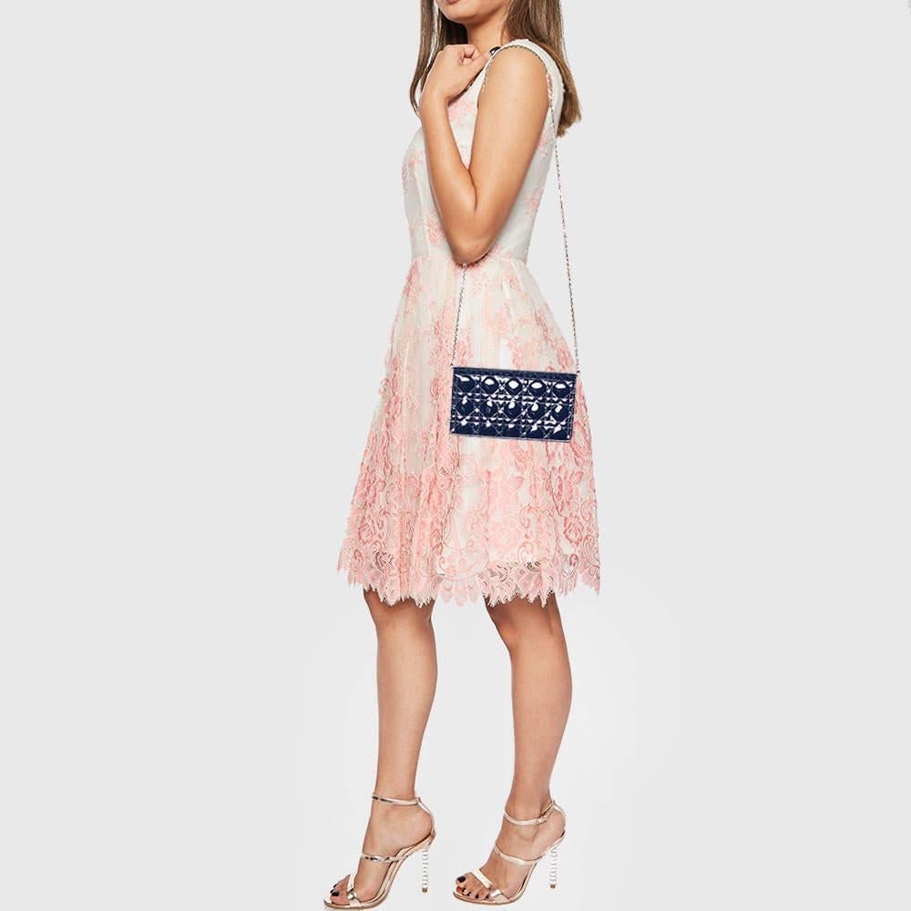 This pretty navy blue Dior clutch has been crafted from patent leather, and it carries the signature Cannage quilt. It is equipped with a leather interior and complete with a chainlink sling and dangling 'DIOR' letter charms in gold-tone