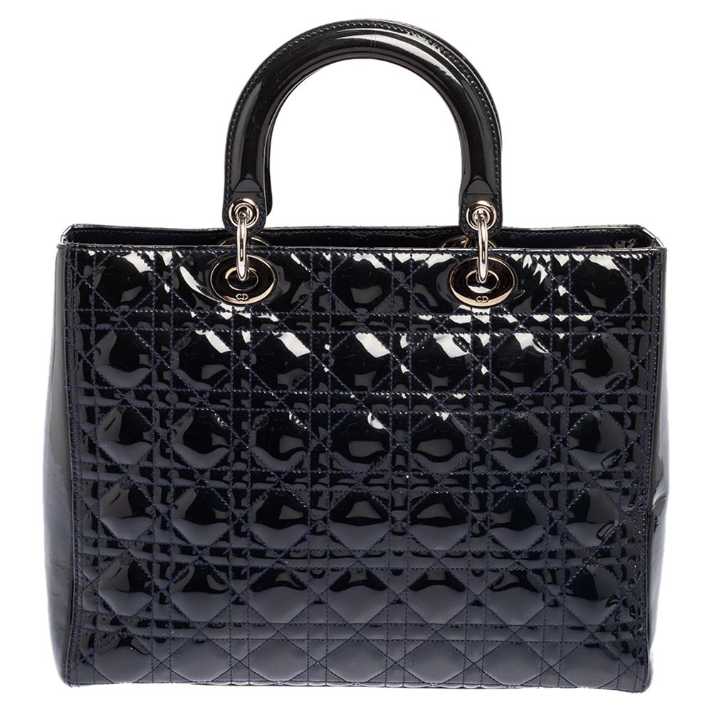 A timeless status and great design mark the Lady Dior tote. It is an iconic bag that people continue to invest in, to this day. This navy blue Lady Dior tote has been crafted using patent leather and carries the signature Cannage quilt. It is