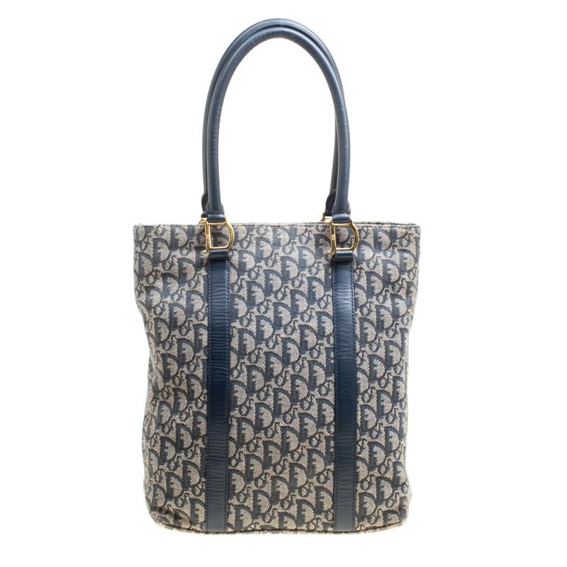 This feminine and chic Trotter tote from Dior is crafted from the signature Diorissmo canvas. The bag features dual rolled leather handles and leather trims to the front with gold-tone D links. The top zip closure opens to a nylon lined interior
