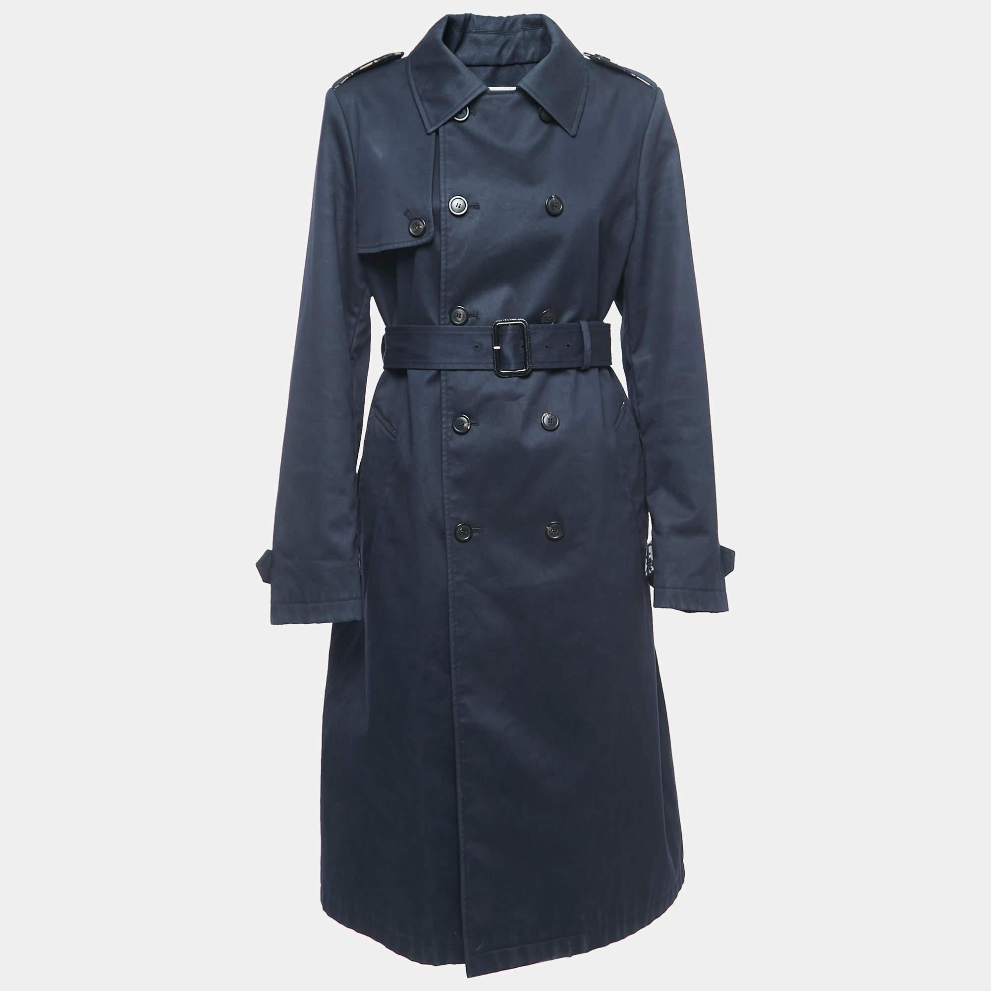 Let this Dior trench coat be your style companion for chilly days. Crafted with precision from the finest materials, it showcases the epitome of craftsmanship and style, making a timeless statement in any wardrobe.

