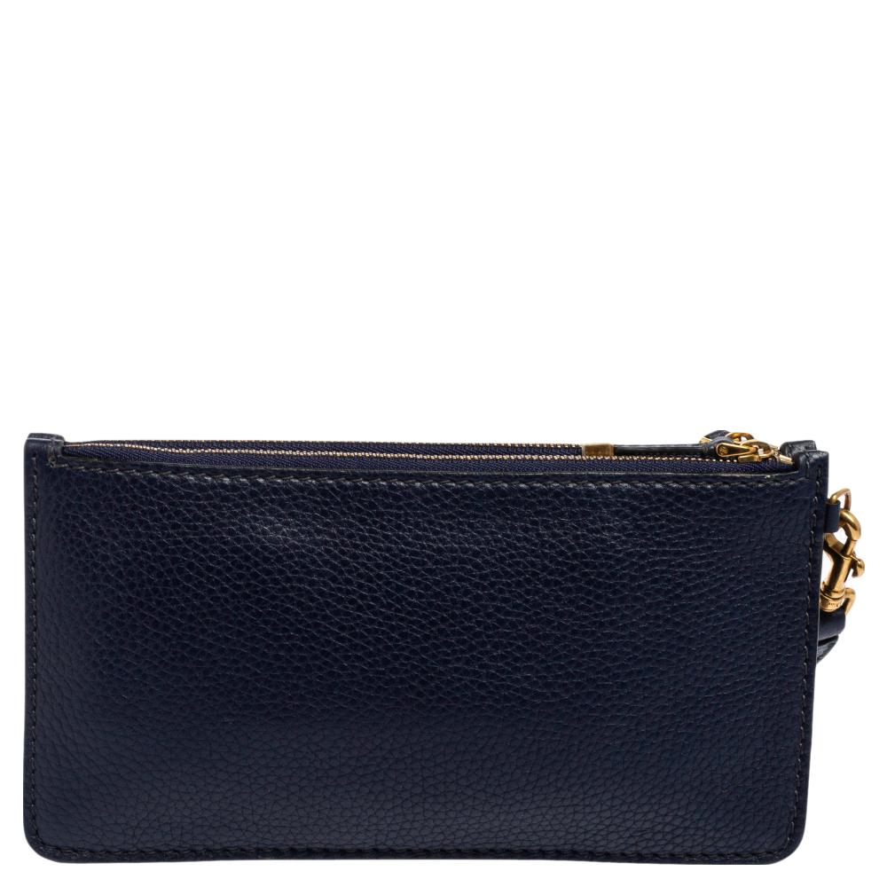 Dior's wristlet pouch crafted using grained leather has a compact size and a navy blue exterior. It comes fitted with a wristlet, a zipped interior, and is decorated with a House code at the front.

Includes: Original Dustbag