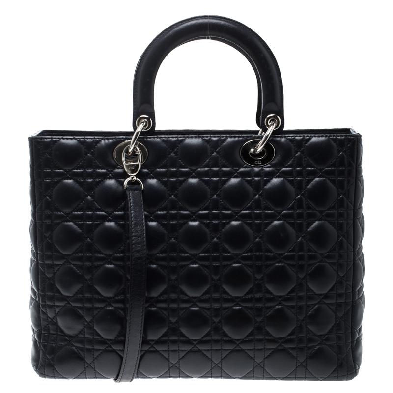 The Lady Dior tote is a Dior creation that has gained lovers worldwide. Crafted from navy blue leather this tote carries a quilted exterior. It features dual rolled top handles, a shoulder strap, classic Dior letter charms and protective metal feet.