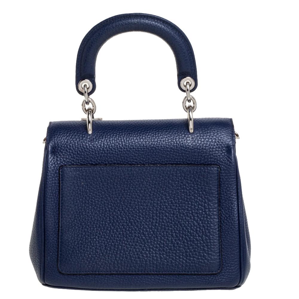 Pretty in navy blue, this Dior bag is crafted from leather and designed with a front flap and a single top handle. The leather-lined interior houses an open compartment that can easily accommodate your daily essentials and the bag is complete with