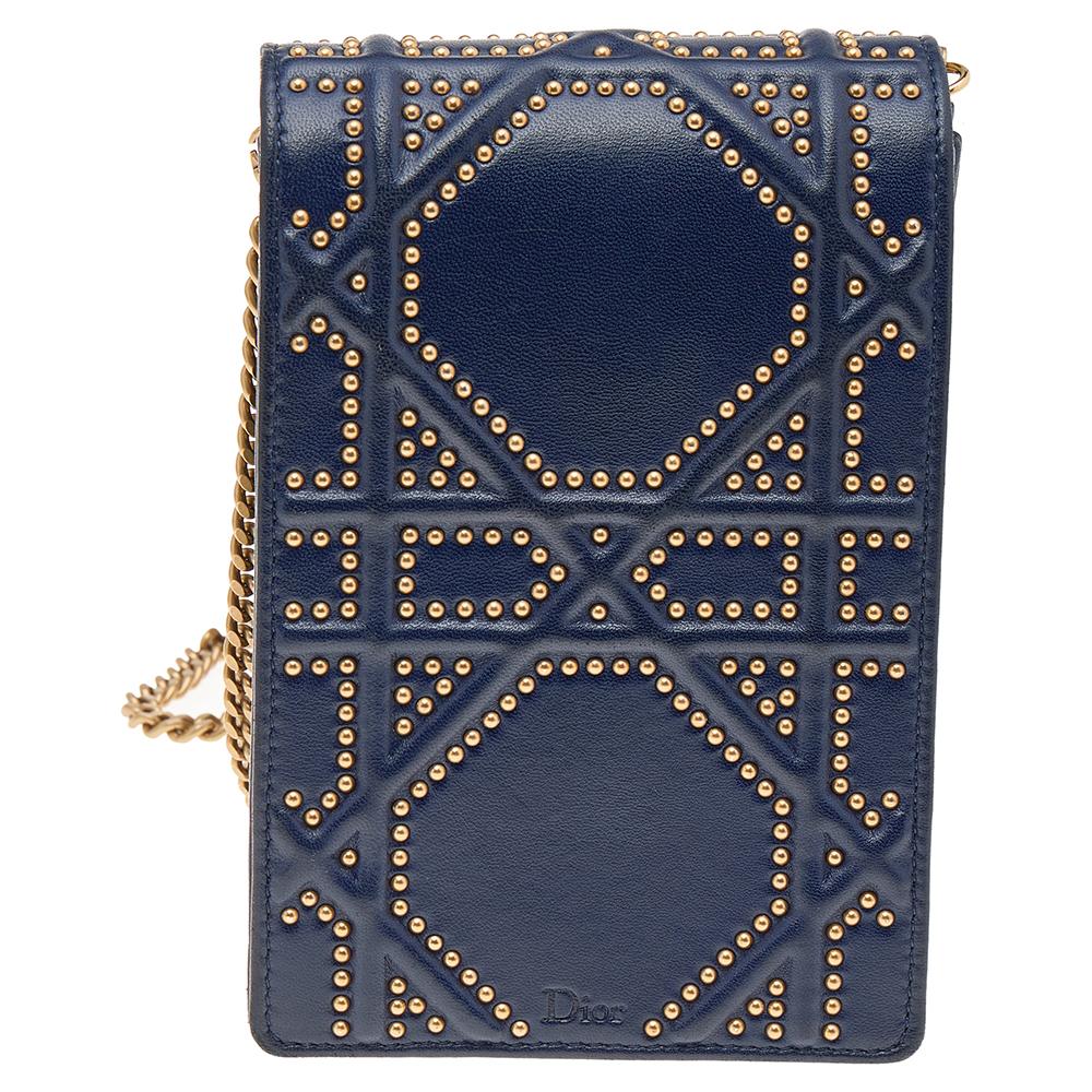 This Diorama clutch is so adorable! From its structured shape to its artistic craftsmanship, the piece sweeps us off our feet. It has been crafted from navy blue leather and detailed with studs in the brand's Cannage pattern. The signature crest