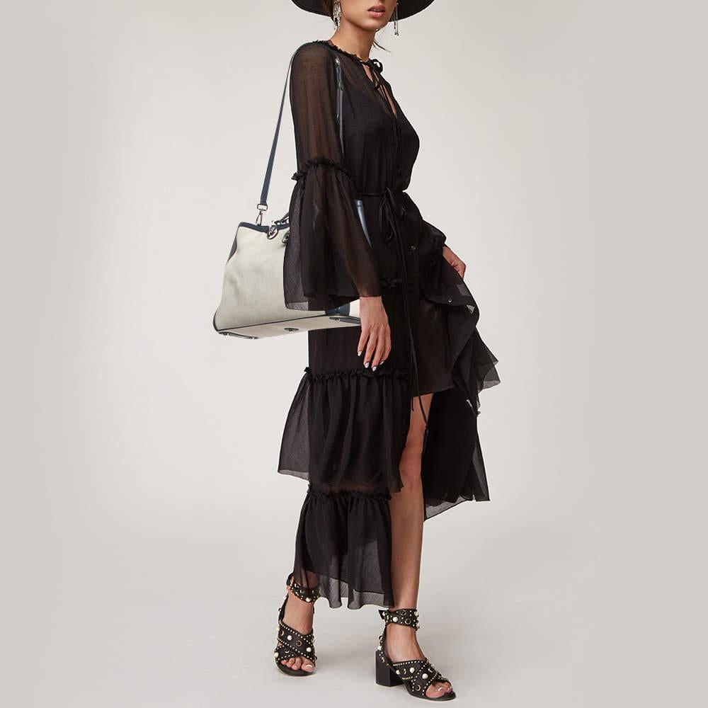 This shopper tote by Dior is a luxe rendition of an everyday staple. It has a spacious compartment  two handles  and silver tone hardware. It is a fine accessory for daily use.