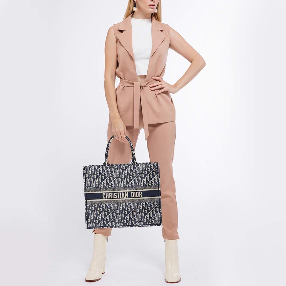 Designed by Maria Grazia Chiuri, the Dior Book Tote is a coveted travel accessory for people with style. The large Book tote here is crafted using canvas into a beautiful structure and covered in the Oblique motif all over. Two handles, the