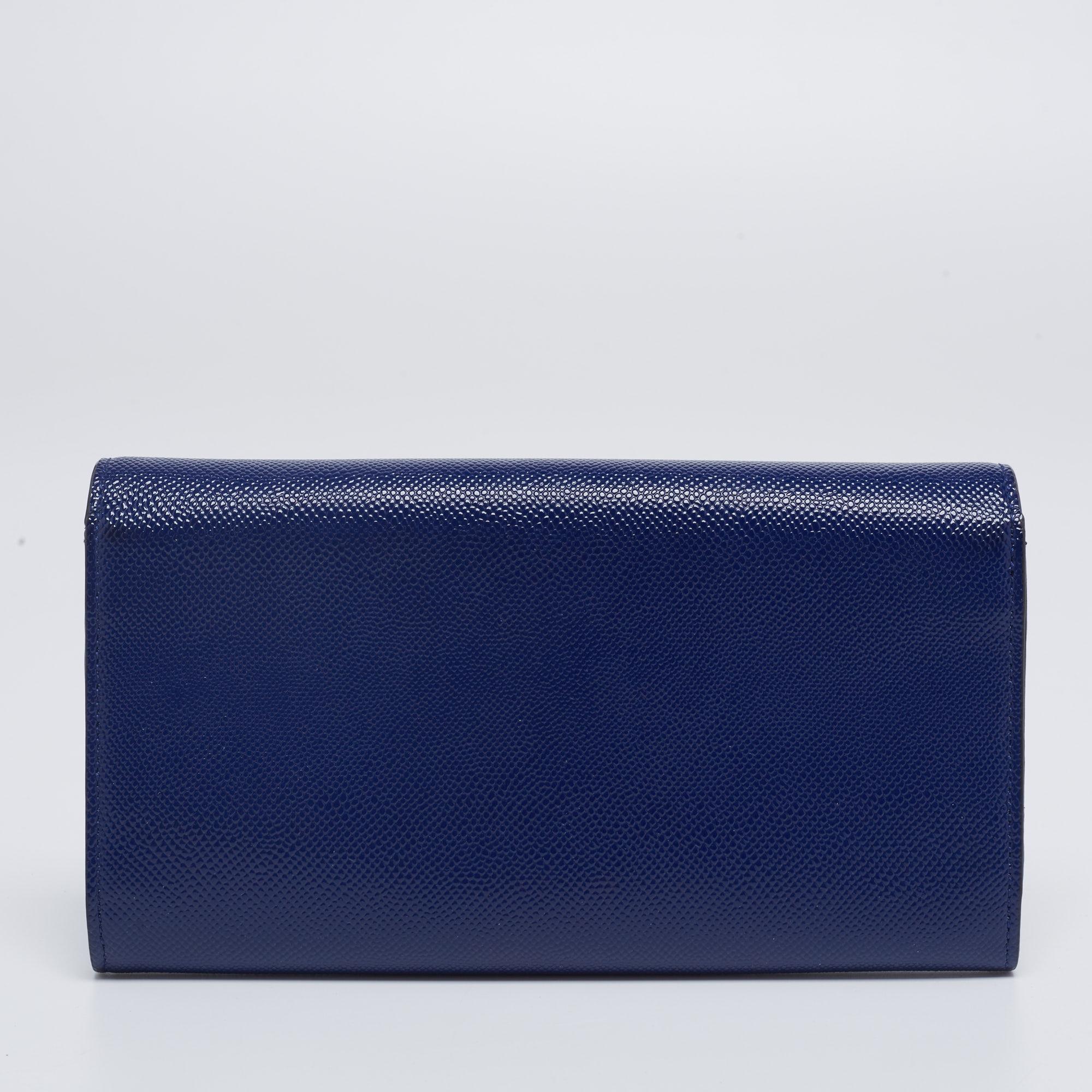This Mania Rendez-Vous wallet from the House of Dior is both classy and chic. It showcases a navy-blue patent leather exterior, with the signature CD logo accent highlighting the front. This wallet opens to a fabric-leather interior that houses