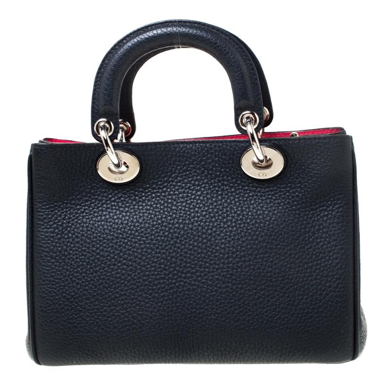 The Diorissimo tote from Dior is a timeless piece. The leather bag comes in a luxurious navy blue hue with silver-tone hardware and Dior letter charms. It features double top handles, a detachable shoulder strap and protective feet at the bottom. A