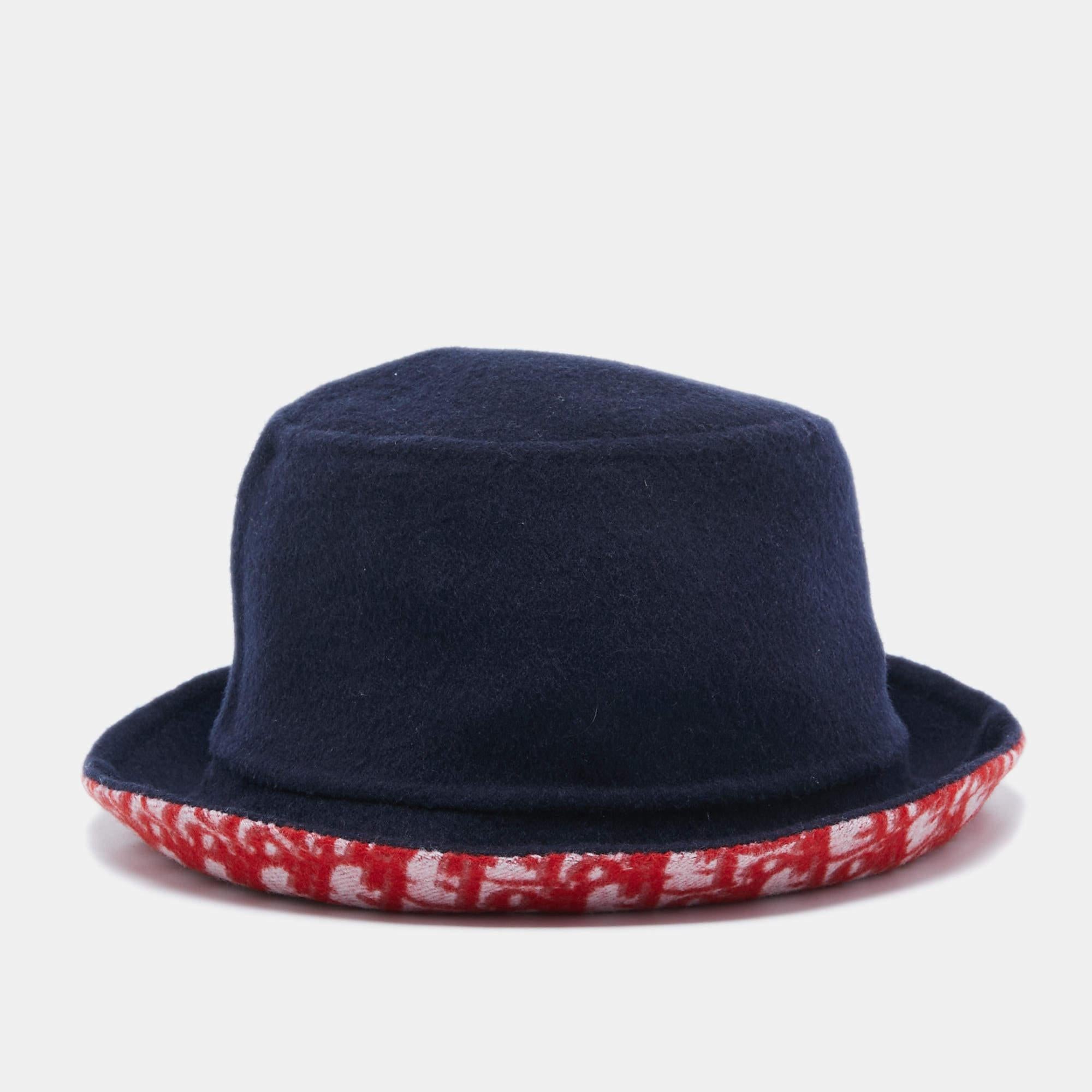 The Dior hat is a luxurious accessory blending style and versatility. Crafted with precision, it features the iconic Dior Oblique pattern on one side, offering a seamless transition between navy blue and red, ensuring a fashion-forward statement for
