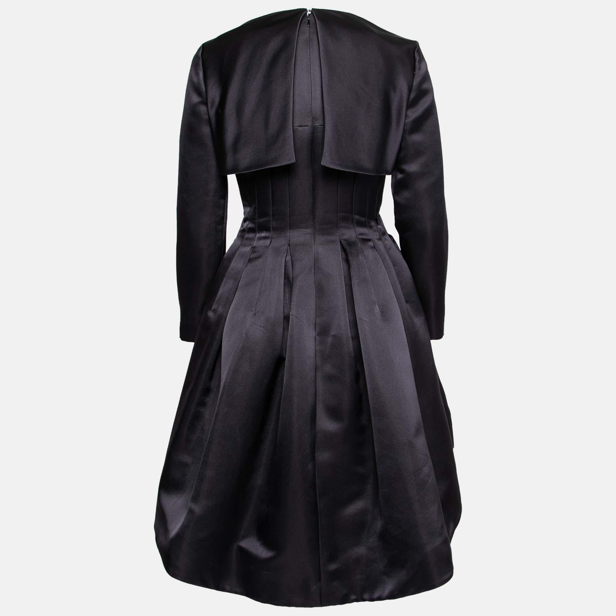 This Dior crop jacket dress is sure to be the topic of the evening! The stunning navy blue dress is sleeveless while the jacket has long sleeves. The dress is complete with a bow detail on the waist and a pleated silhouette. Truly fit for those
