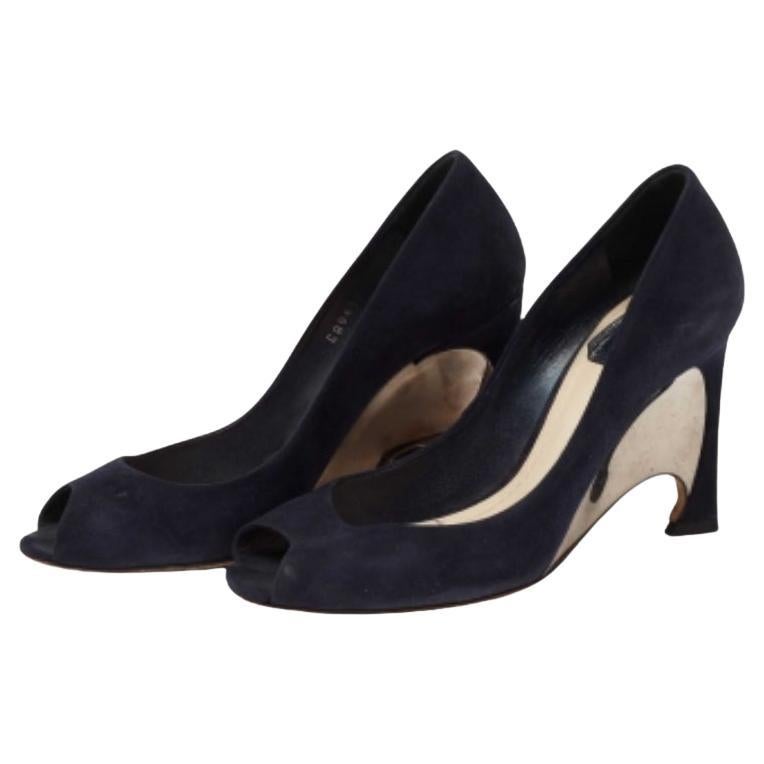 This pair of Dior pumps is the epitome of feminine style. Created from suede, it flaunts peep toes, silver-tone hardware, and leather insoles. The uniquely-carved wedge heels of these shoes serve as a standout feature.
