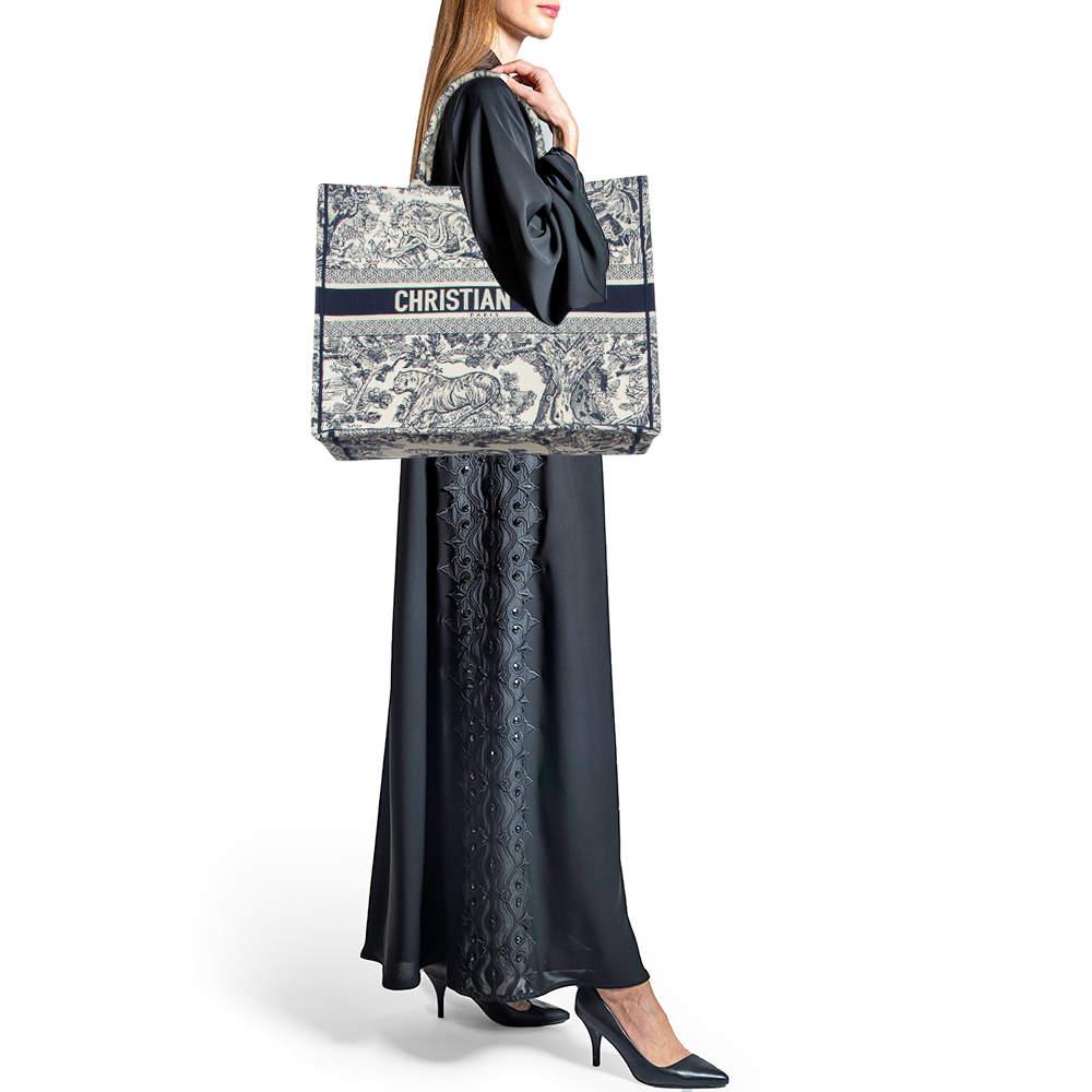 Designed by Maria Grazia Chiuri, the Dior Book Tote is a travel accessory for people with style. The bag here is crafted using canvas into a beautiful structure and covered in Toile De Jouy embroidery all over. Two handles, the 'Christian Dior'