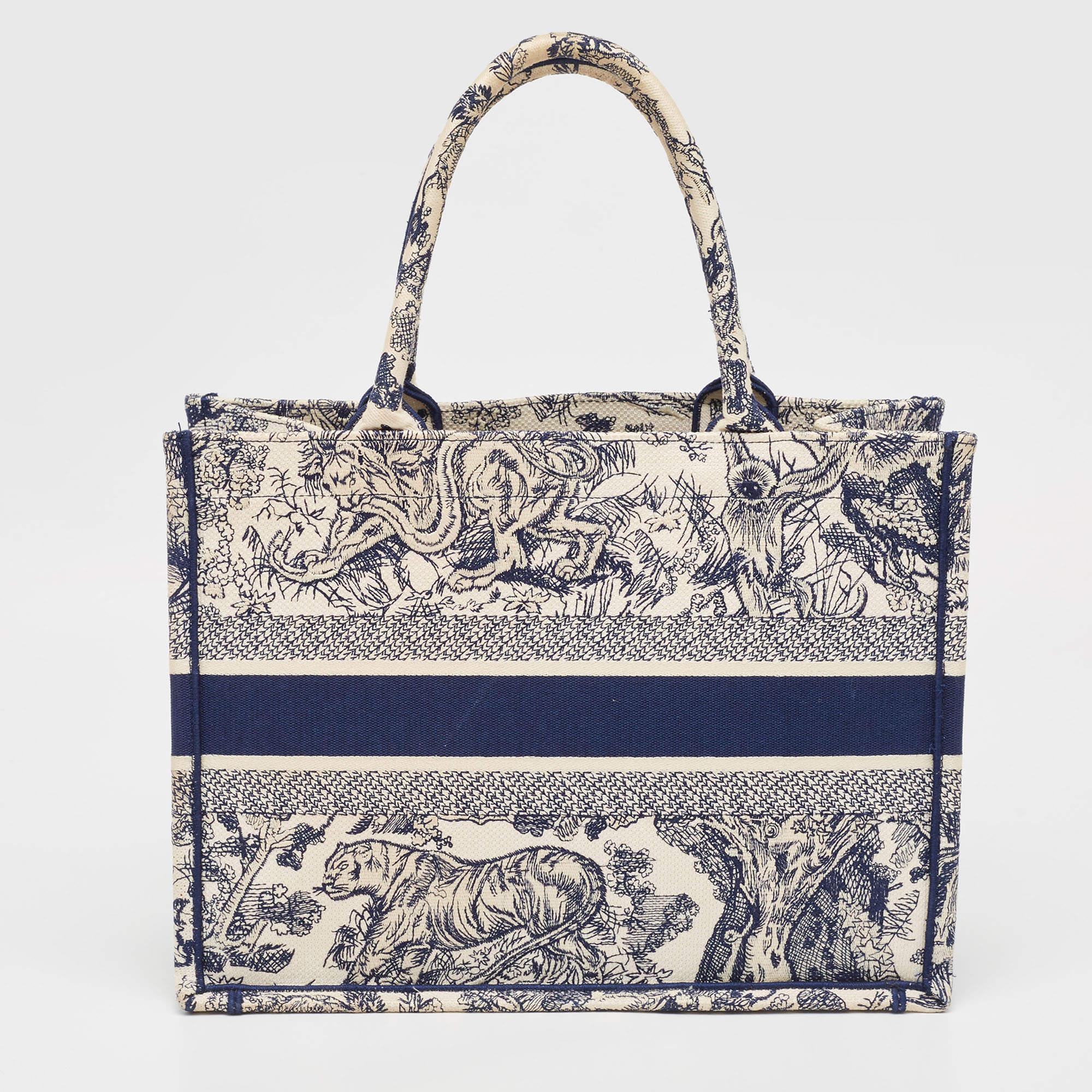 Designed by Maria Grazia Chiuri, the Dior Book Tote is a travel accessory for people with style. The bag here is crafted using canvas into a beautiful structure and is covered in signature prints all over. Two handles, the 'Christian Dior'