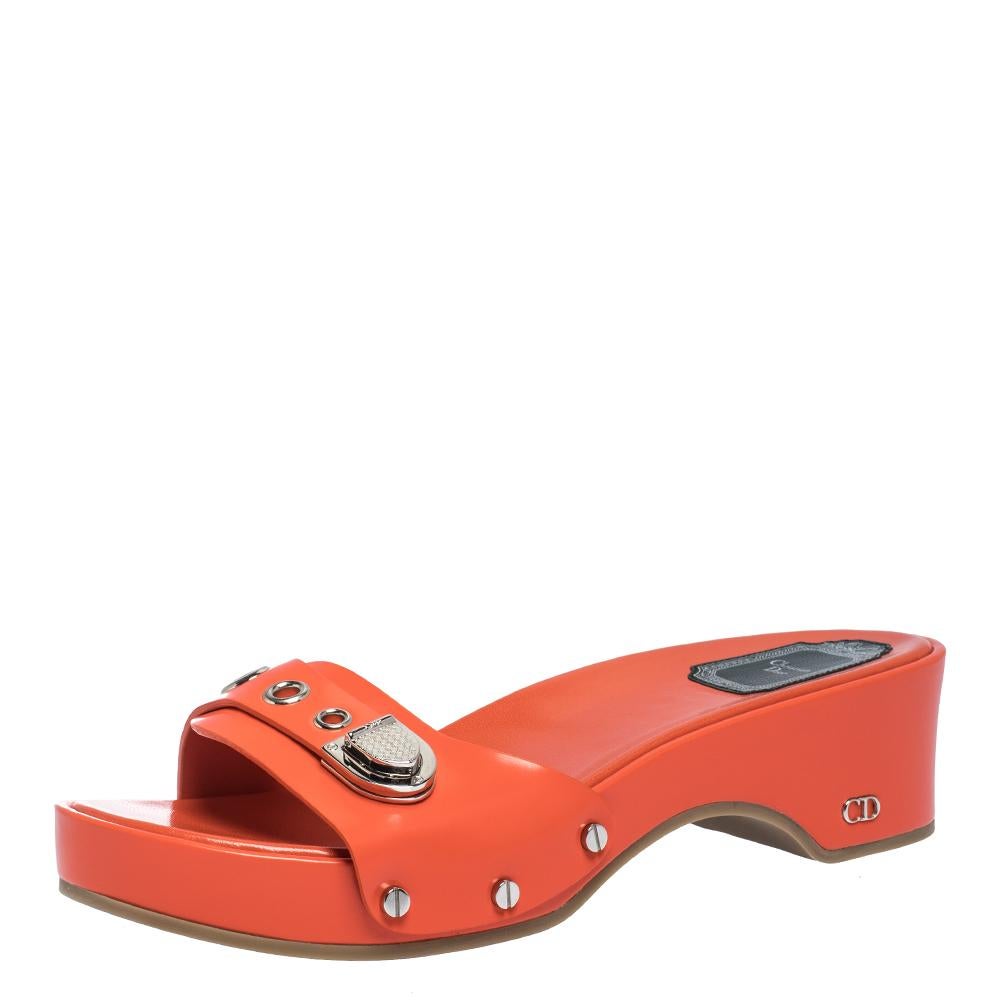These impressive sandals come in a neon orange color. Designed by Dior, these are crafted from quality leather. With a 5 cm heel and platforms, this pair features buckle detail flaunting the brand logo and stud detailing in silver-tone hardware.