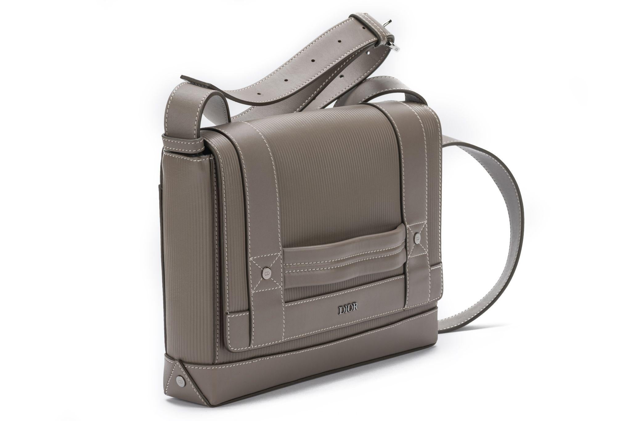 Dior messenger bag in light grey made of leather. Comes with a adjustable shoulder strap measures 20” and original dustcover.