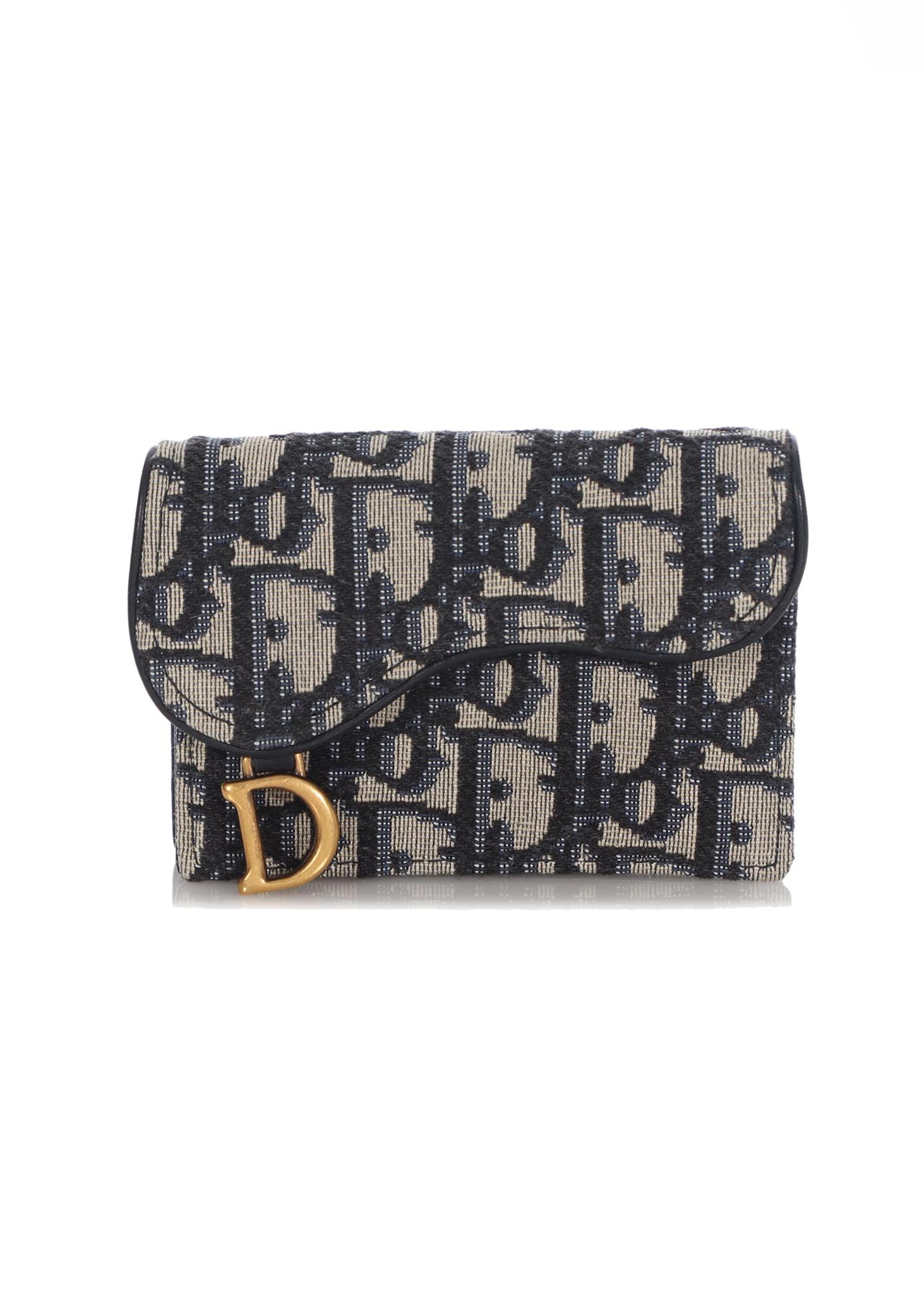 The Saddle flap card holder offers a practical and compact alternative to the traditional Saddle wallet. Its artisanal design, crafted in blue Dior Oblique jacquard, assures durability and presents a spacious main compartment, two patch pockets and