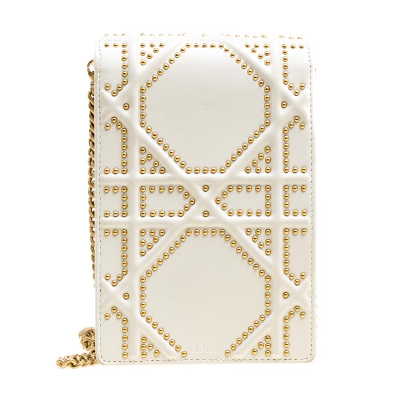 This Diorama clutch is so adorable! From its structured shape to its artistic craftsmanship, the piece sweeps us off our feet. It has been crafted from off-white leather and detailed with studs in the brand's Cannage pattern. The signature crest