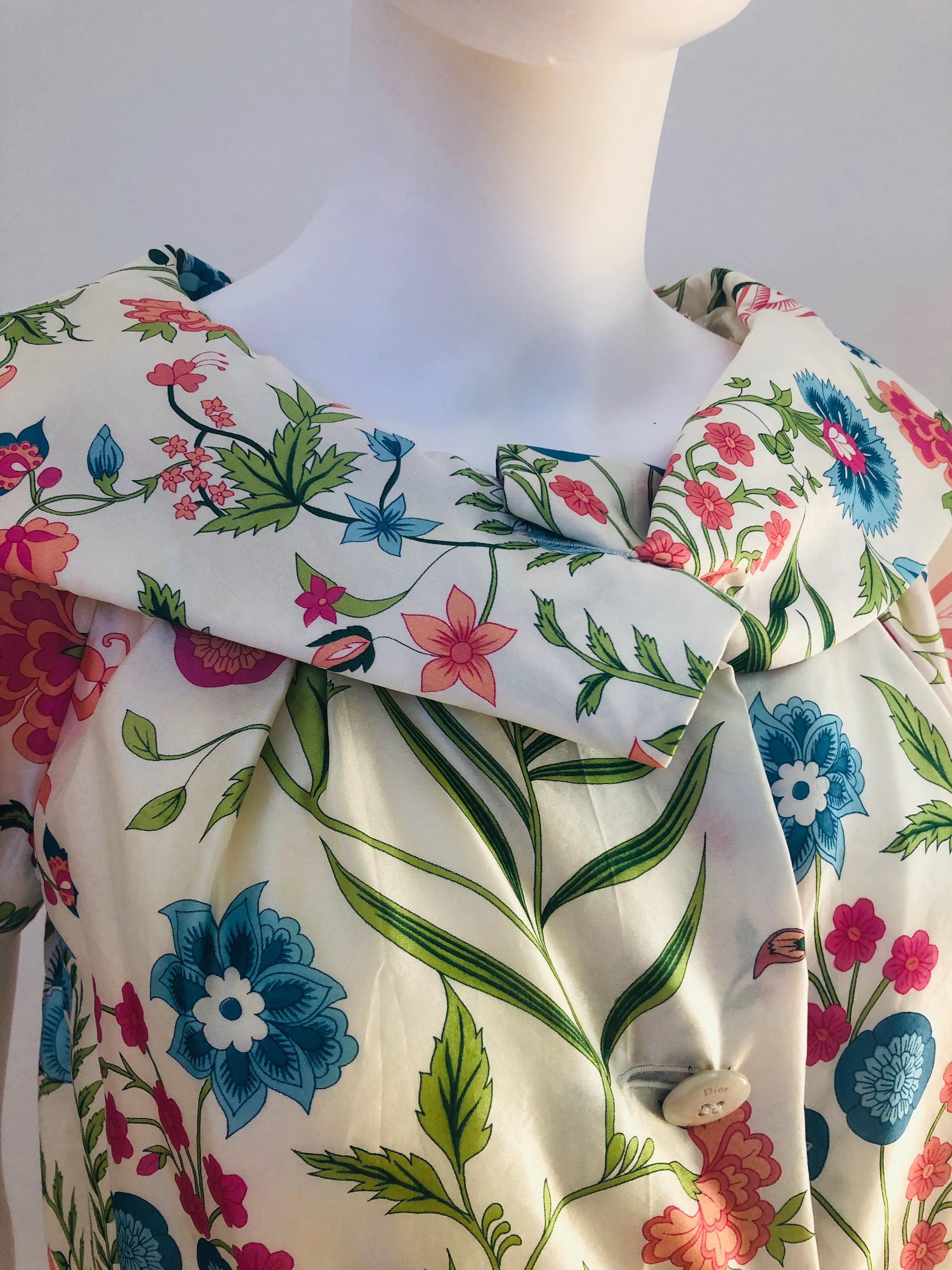 Offered is an early 2000 Christian Dior (purchased at the Dior boutique in Aspen) charmeuse silk shawl collar short evening jacket with an off-white / ivory background an a botanical / floral pattern of pinks, blues and greens.   
Evening jacket/