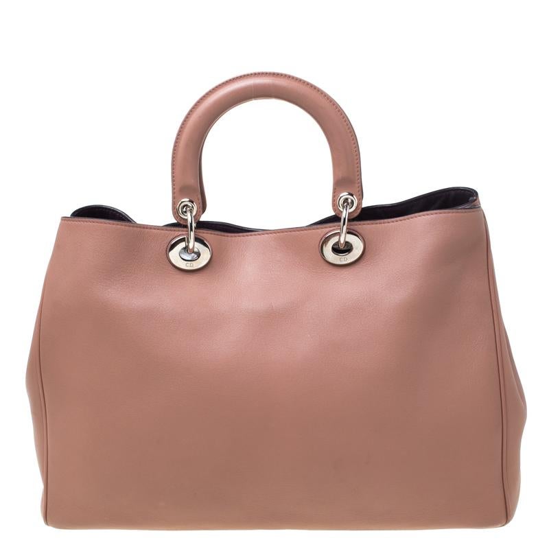 The Diorissimo tote from Dior is a timeless piece. The leather bag comes in a luxurious old rose hue with silver-tone hardware and Dior letter charms. It features double top handles, a detachable shoulder strap and protective feet at the bottom. A