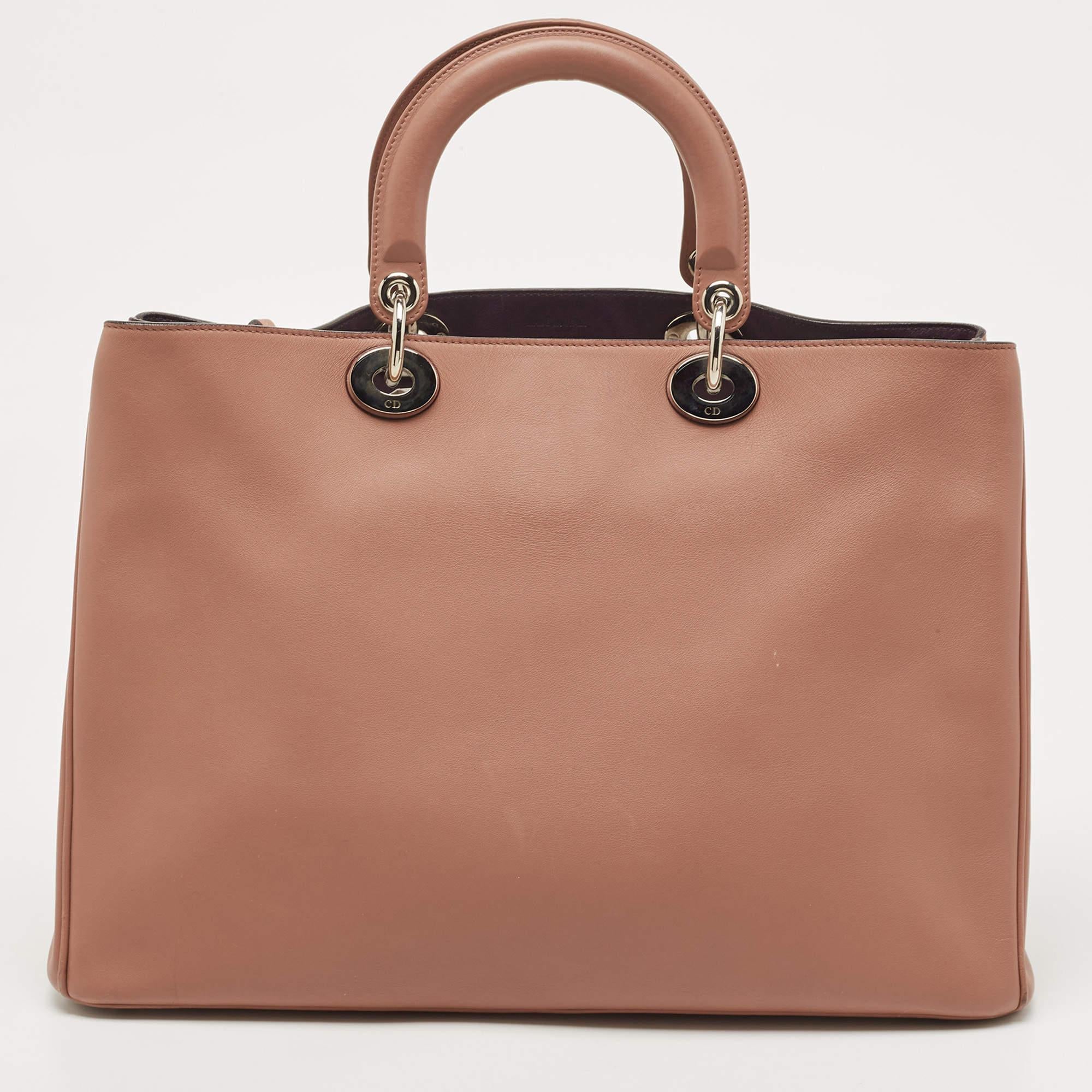 This Diorissimo Shopper tote from the House of Dior will help you keep your belongings safely and stylishly. It is made using leather on the exterior and is highlighted with D.I.O.R charms on the front. It features dual handles, a shoulder strap,
