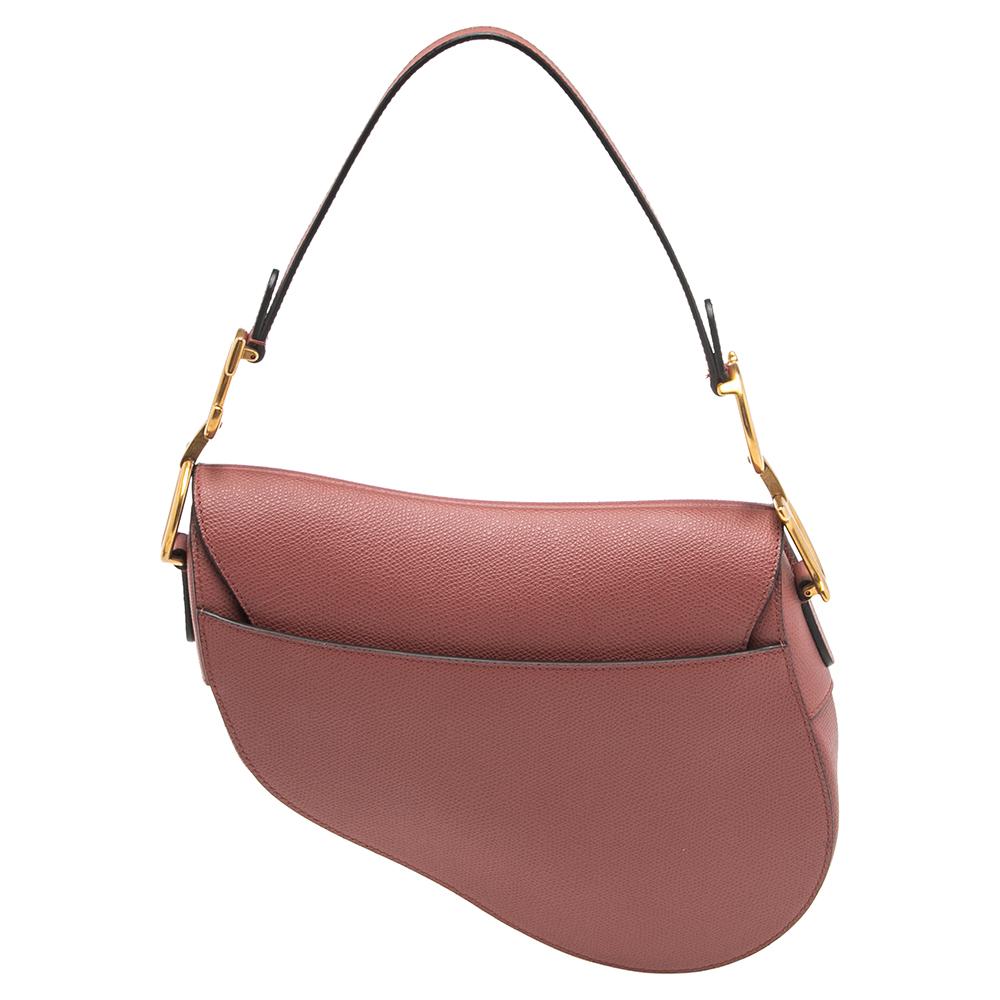 An example of timeless style and great design ideas, Dior's Saddle bag is sought after for all the right reasons. This Saddle bag for women is crafted using old rose leather in the iconic shape and it has gold-tone CD letters to hold the single