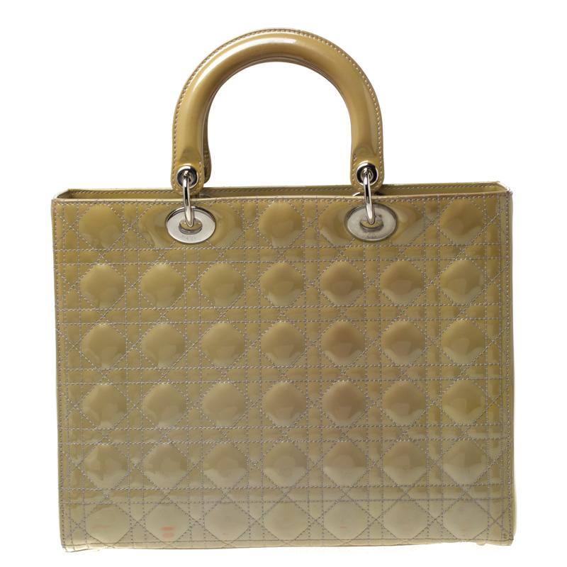 The Lady Dior tote is a Dior creation that was designed in 1994 and has gained lovers worldwide. Crafted from patent leather, this olive green tote carries the signature cannage pattern on the exterior. It is equipped with dual top handles, a