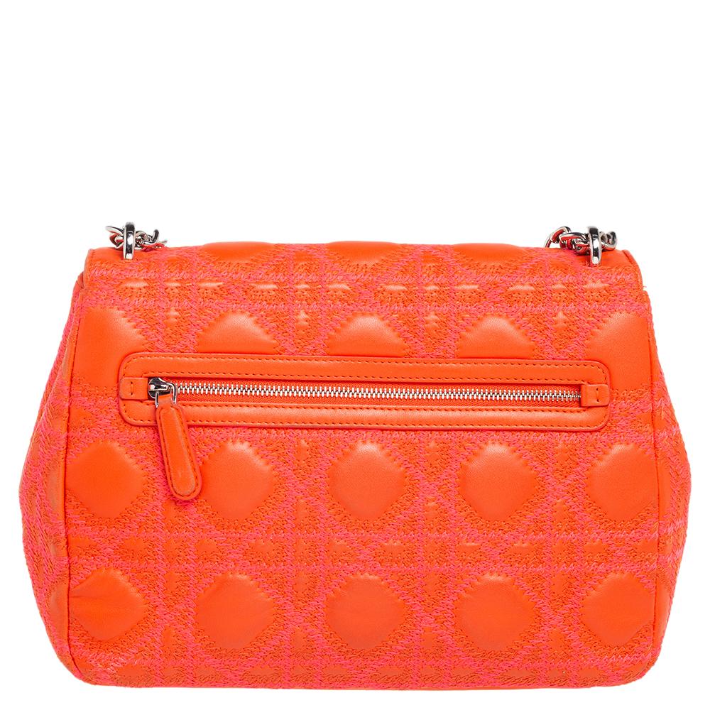 Flap bags like this Miss Dior will never go out of style. Crafted from orange leather, this Dior flap bag features an orange/pink embroidered Cannage exterior and a sliding chain strap. The front flap has a Dior lock that opens to a leather-lined
