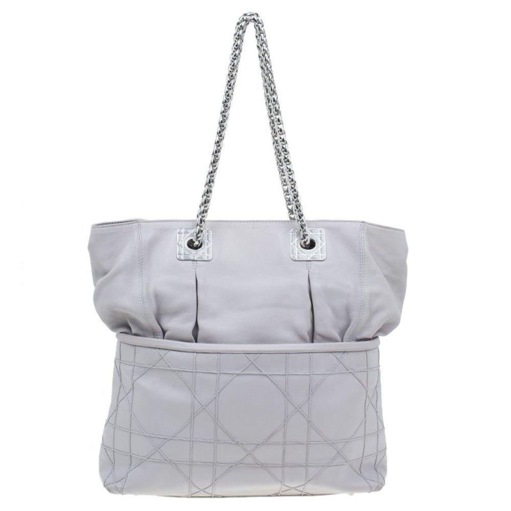 Why wear a basic bag when you can carry this refined So Dior tote from the house of Dior! This everyday tote is made from smooth grey leather with Dior’s signature Cannage pinch stitch pattern, along with polished silver-tone chain link handles and