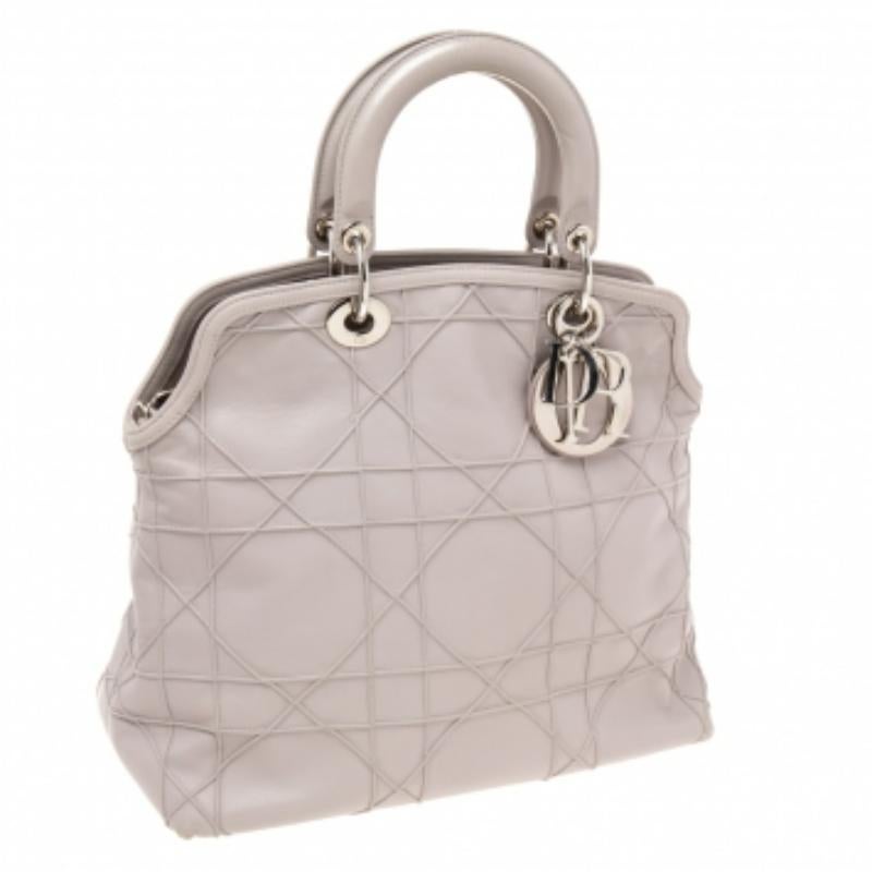 Présenté par la Maison Dior, ce superbe fourre-tout Granville est un véritable accessoire d'apparat. Elle est réalisée en lilas pâle  Cuir de cannage, avec les charmes D.i.o.r. signature perchés sur le devant. Ce fourre-tout est doté de deux